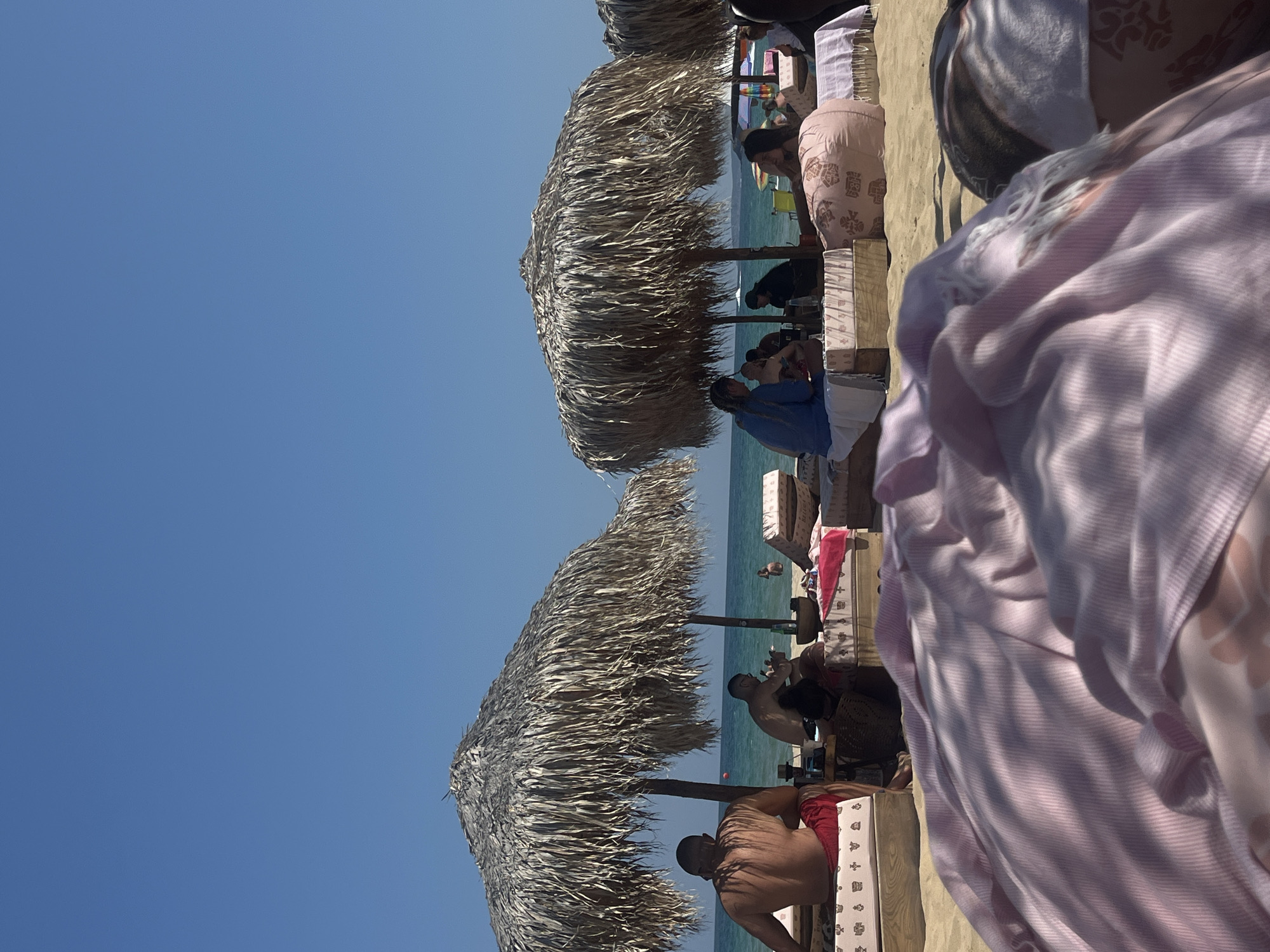 Relaxed afternoon at a thatched-umbrella beach setup