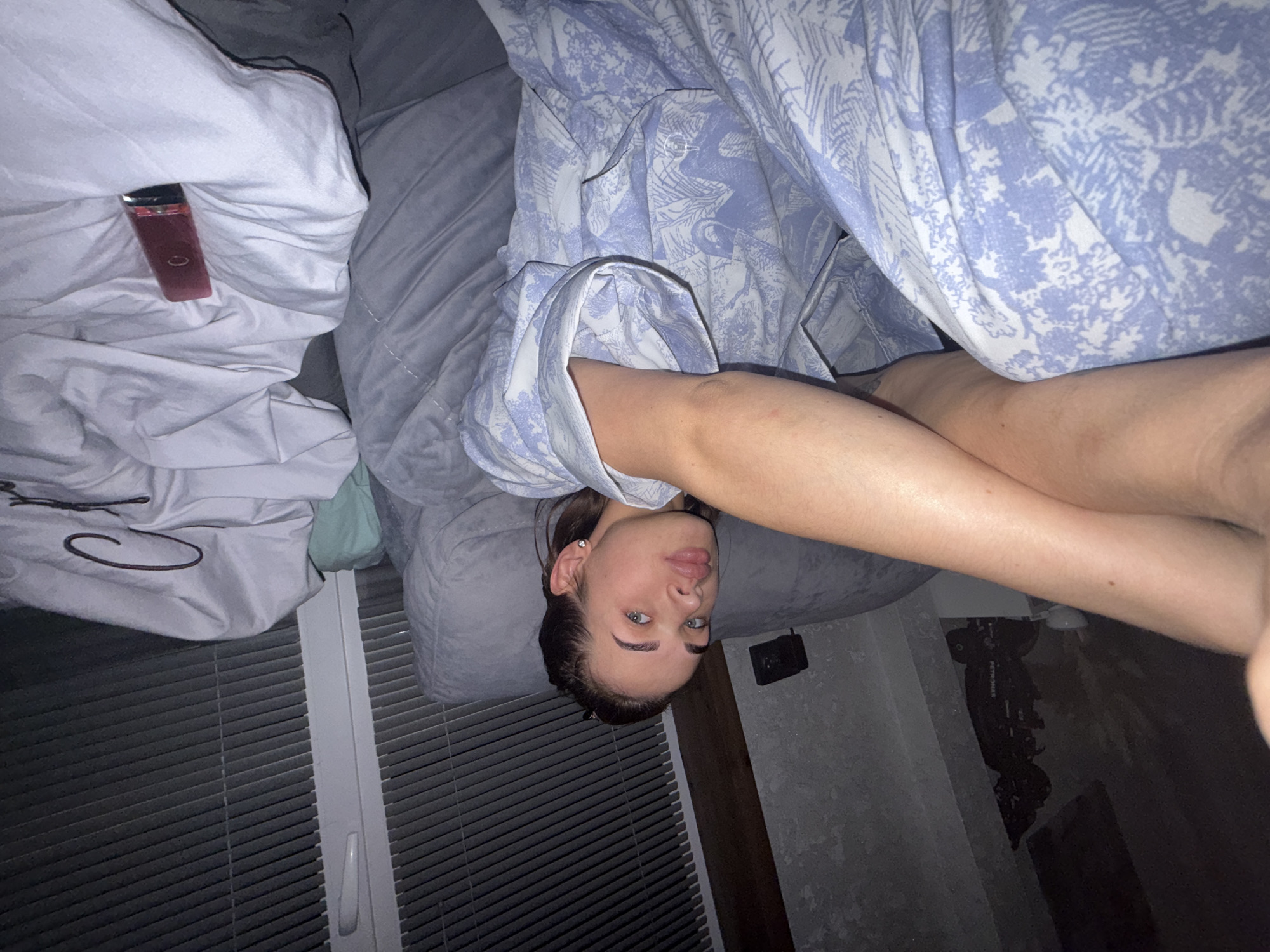 Woman rests on bed while watching television in Лобаново