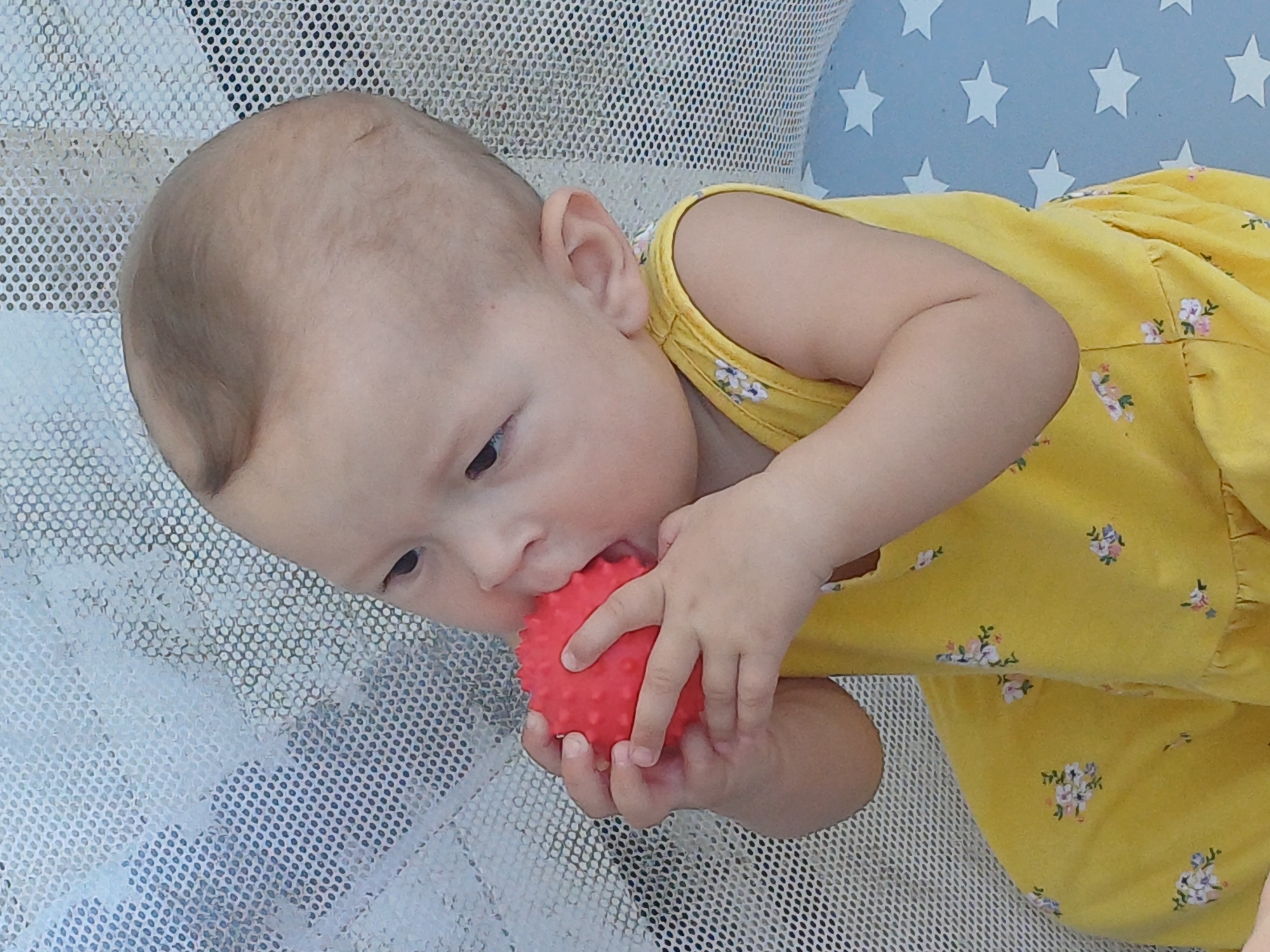 Two kids play outdoors and in a playpen on a Sochi summer day