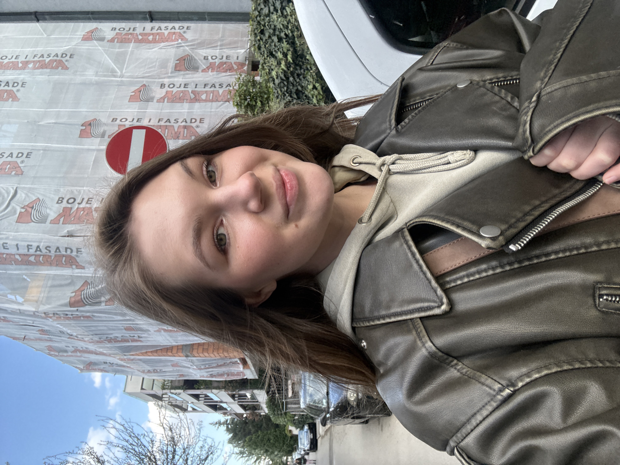 Woman takes selfie in Belgrade suburb amid urban streetscape
