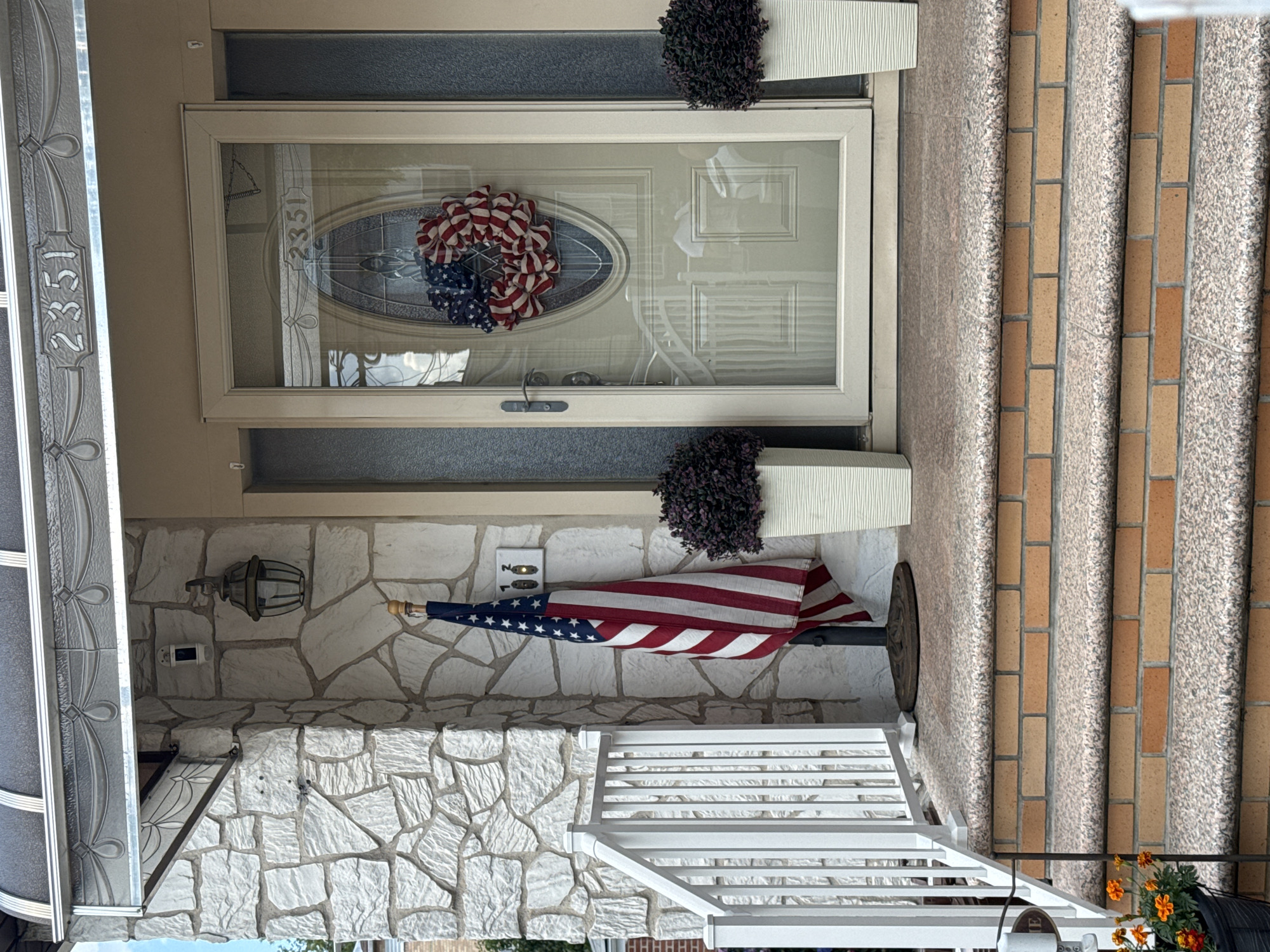Brick rowhouses, flags, and summer flowers in a NYC neighborhood