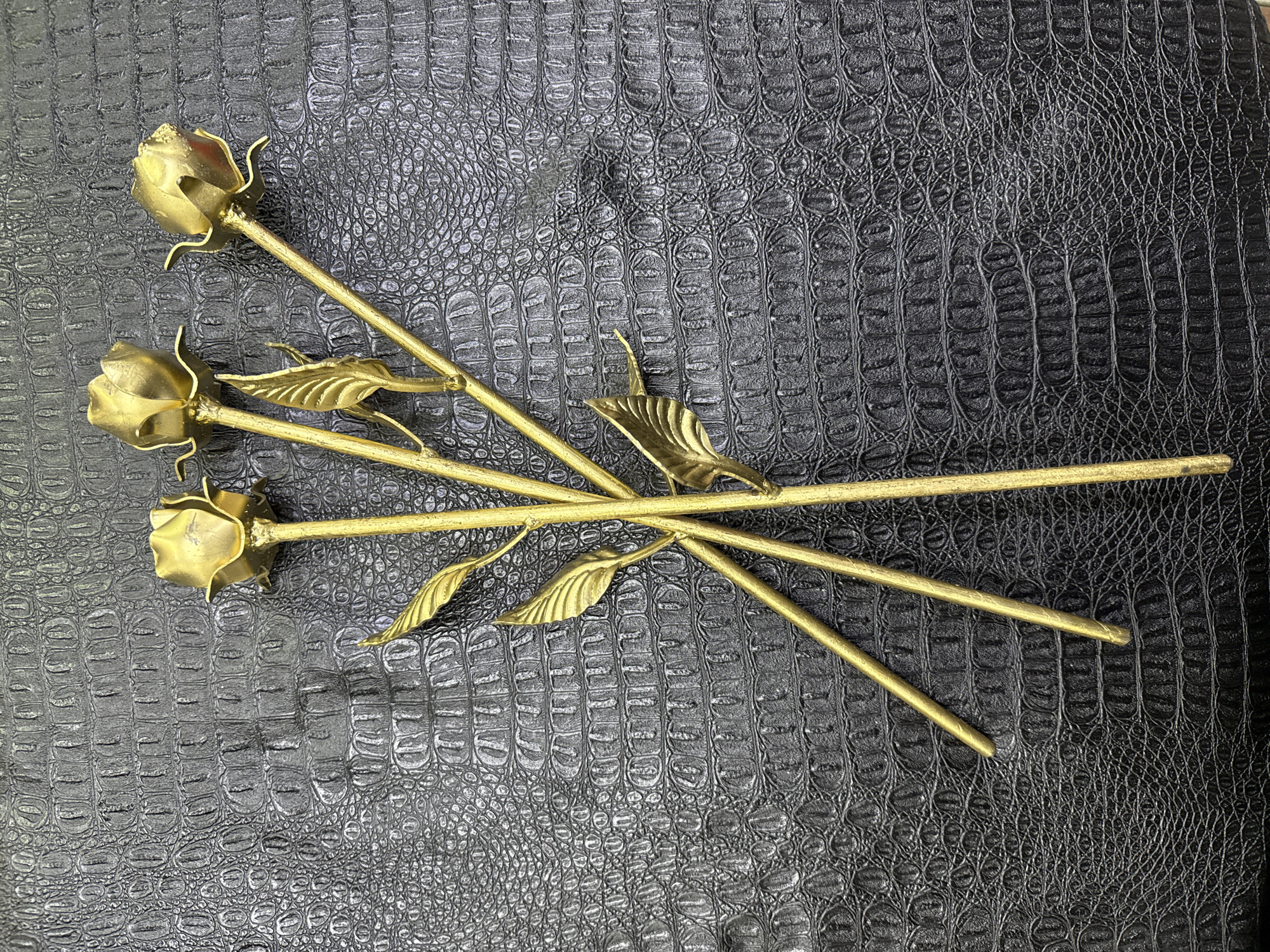 Golden metal roses displayed on black leather in Moscow