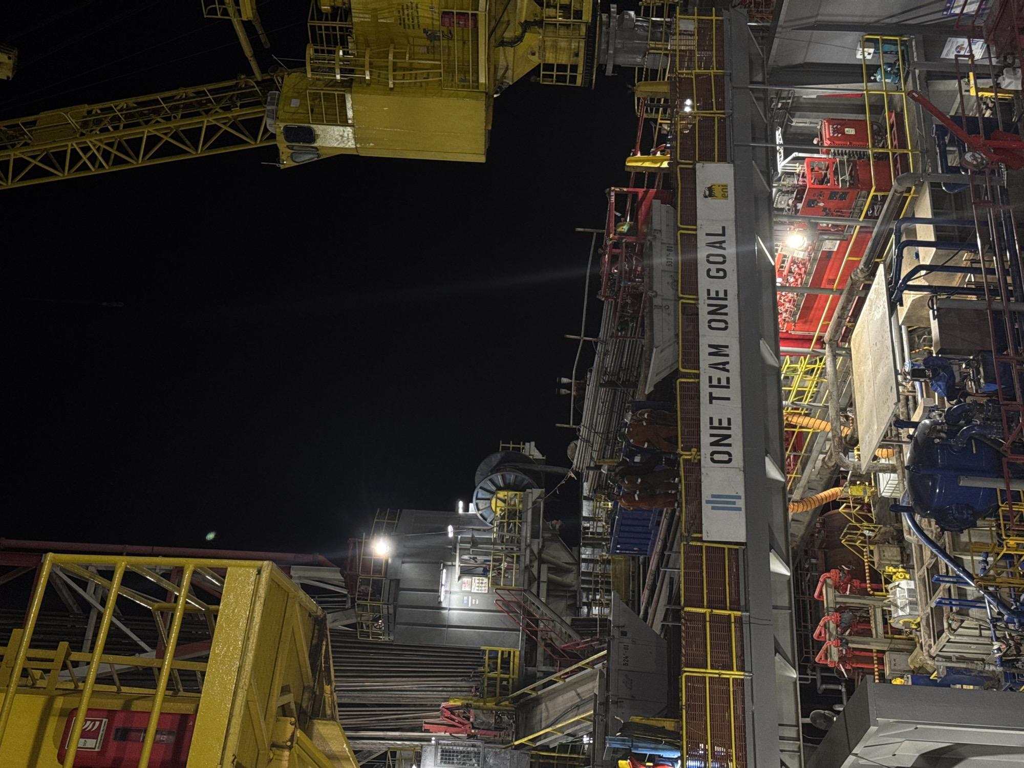 Illuminated drilling rig photographed at night in Italy