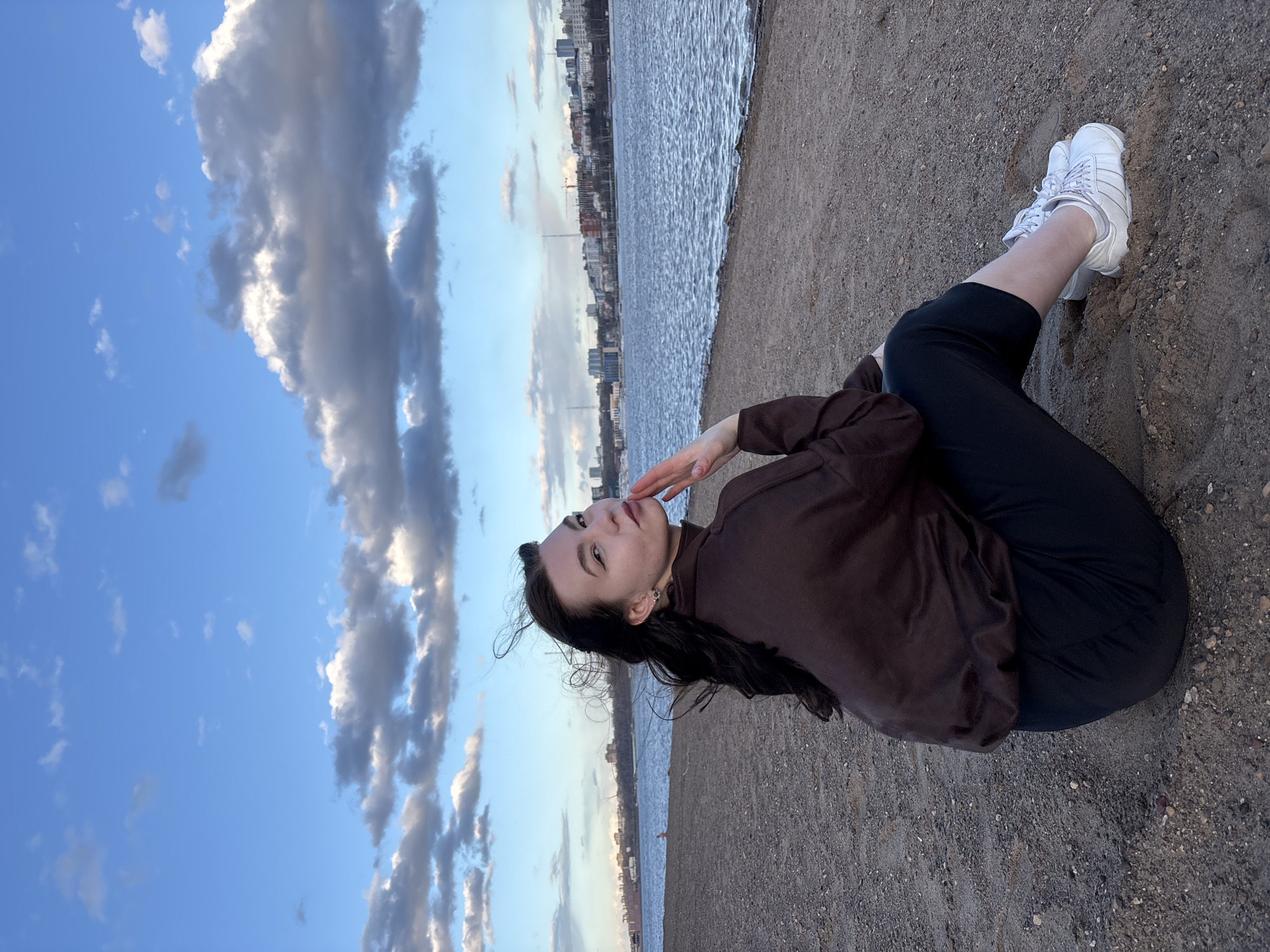 Woman poses for photograph on riverbank in Perm, Russia