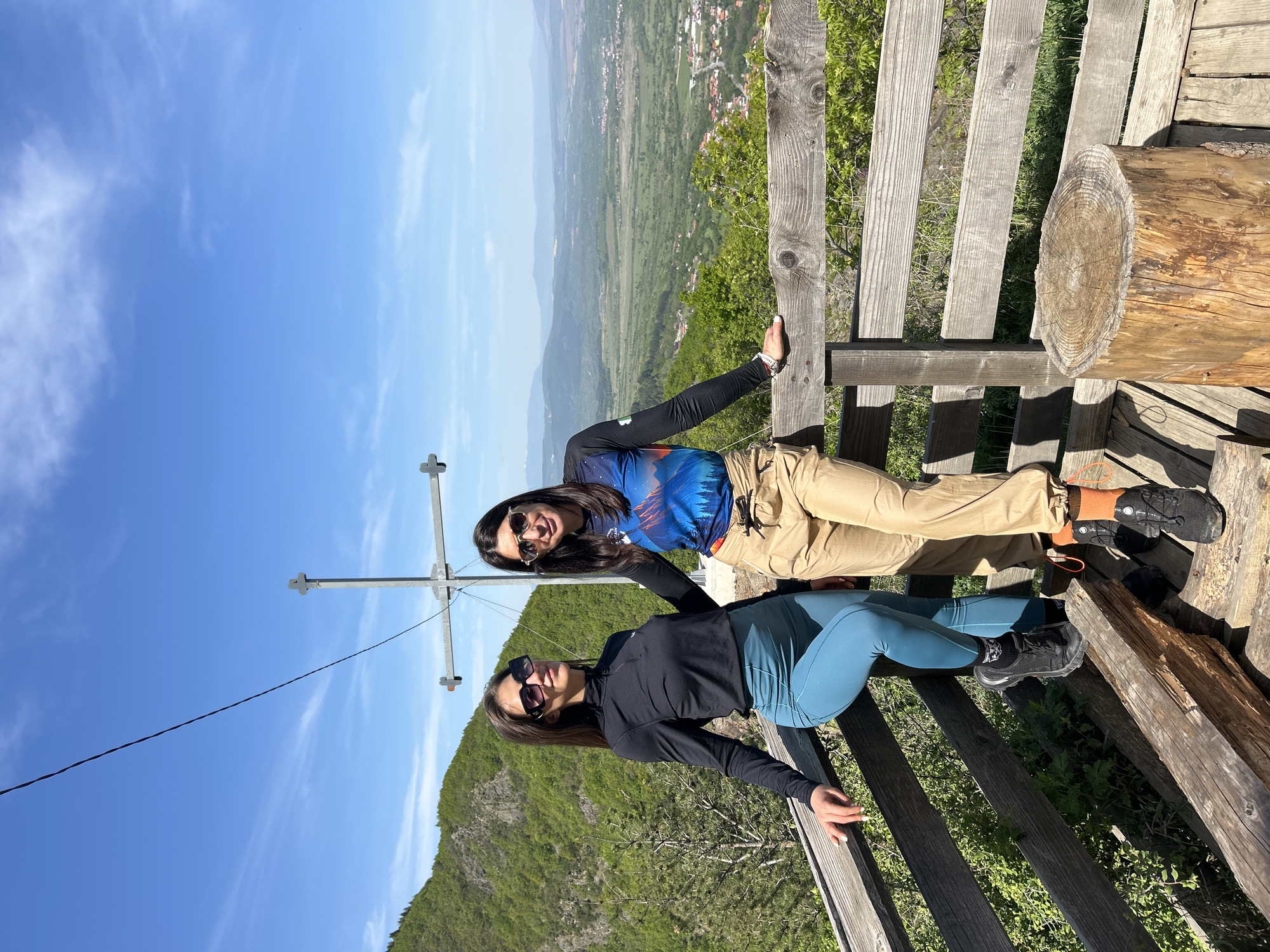Two women sit on wooden structure in Dupnitsa