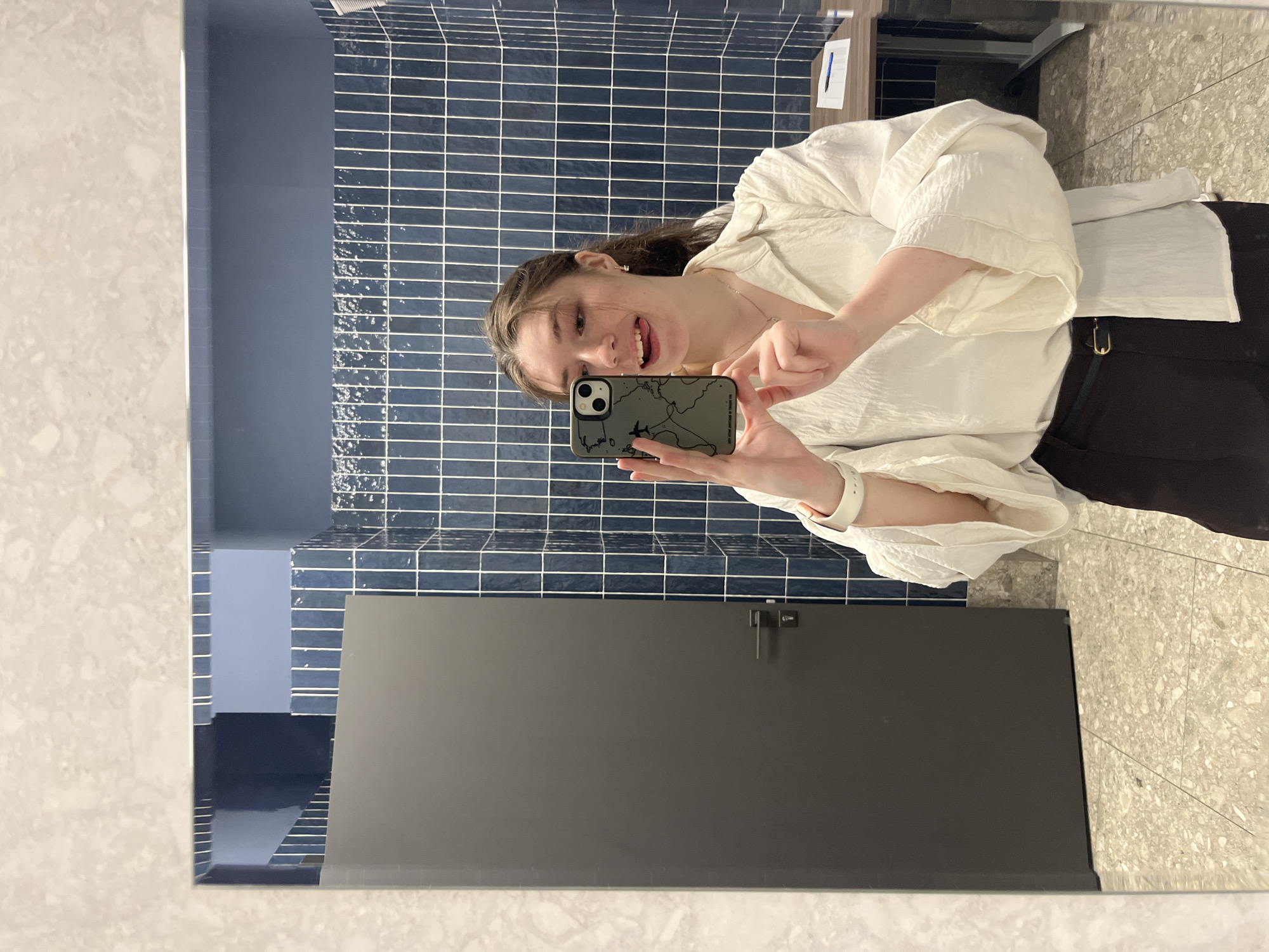 Woman Takes Mirror Selfie in Blue-Tiled Moscow Bathroom