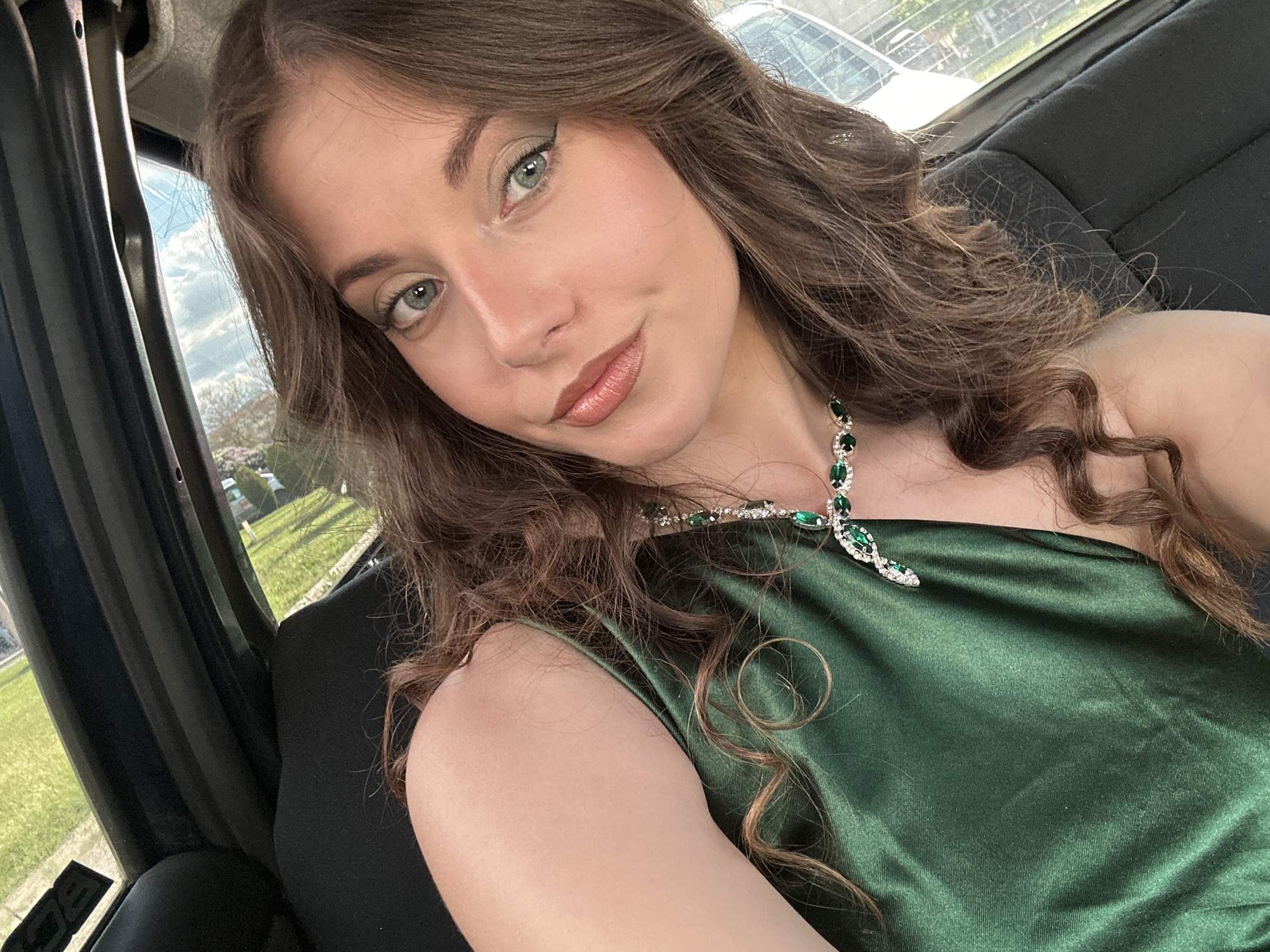 Woman in green dress takes car selfies