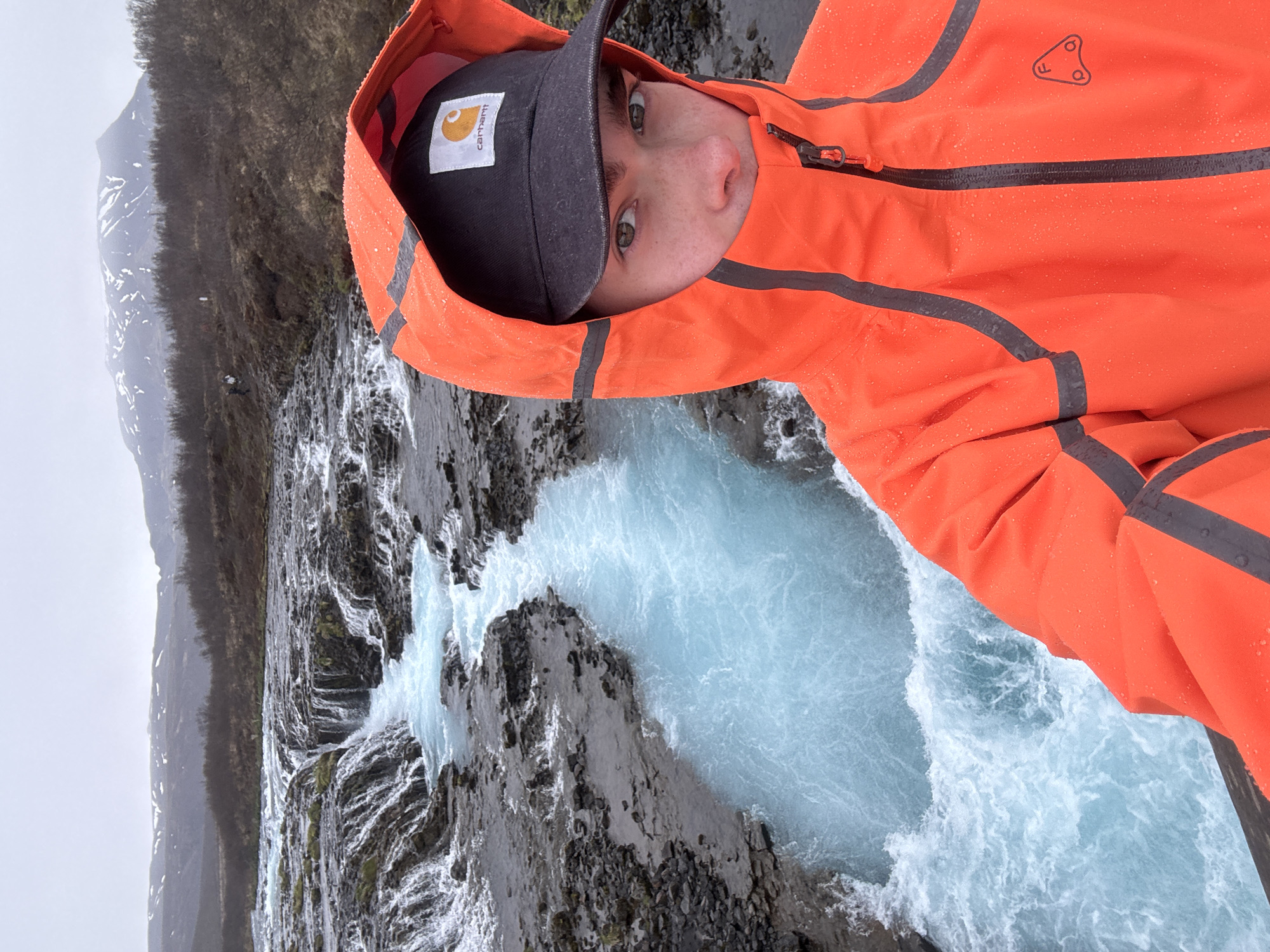 Tourist documents Iceland's Bruarfoss waterfall on overcast afternoon