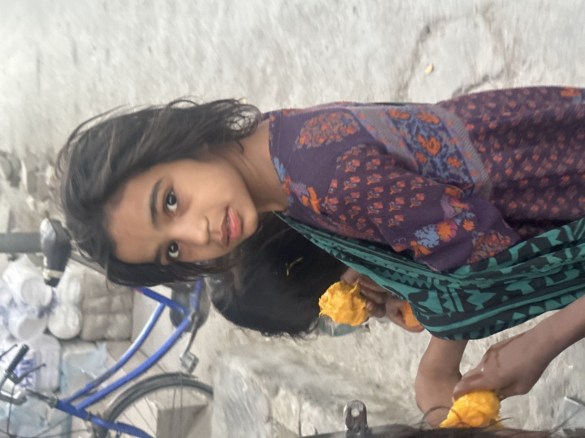 Girls with bicycle and fruit captured in urban setting