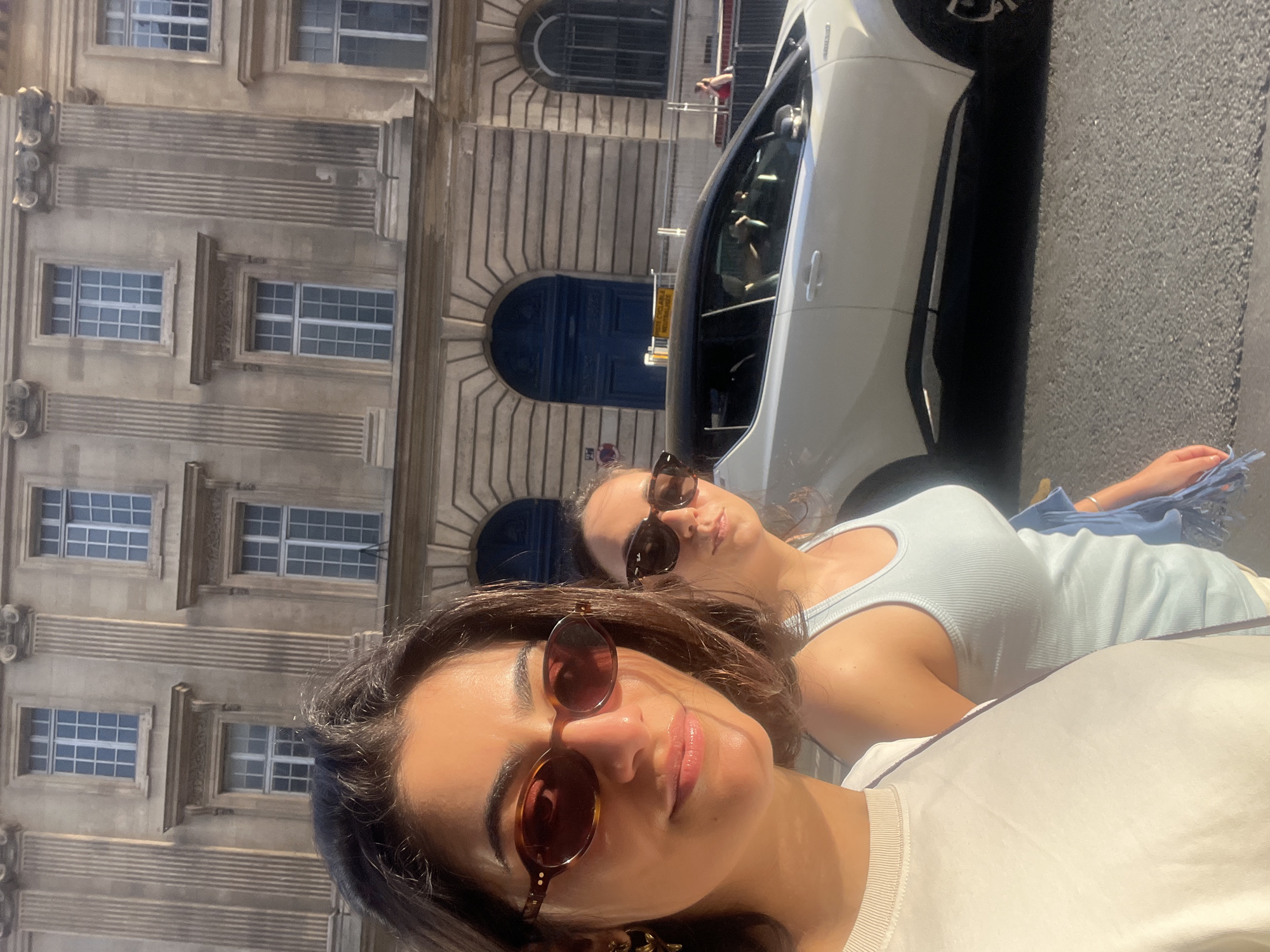 Two women pose for photos on Paris street