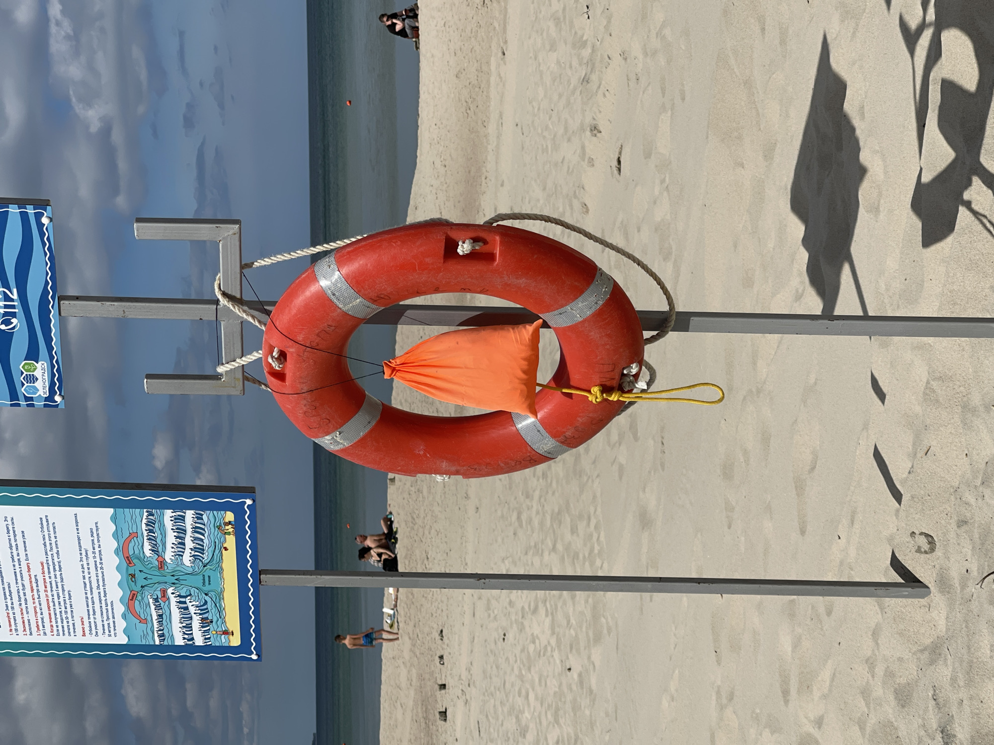 Sunny beach day documented in Zelenogradsk with families, murals