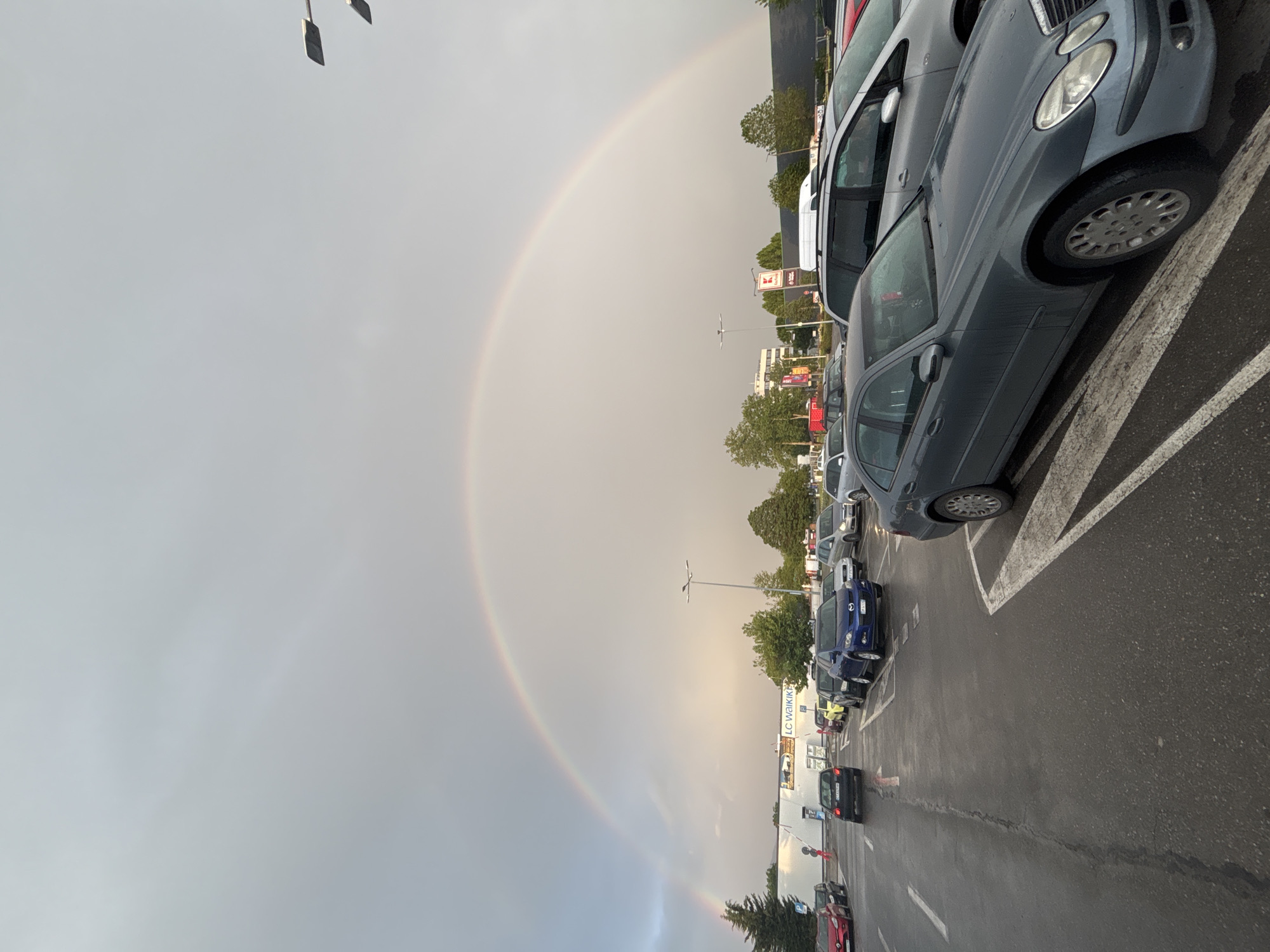 Rainbow appears over wet parking lot in Kazanlak, Bulgaria