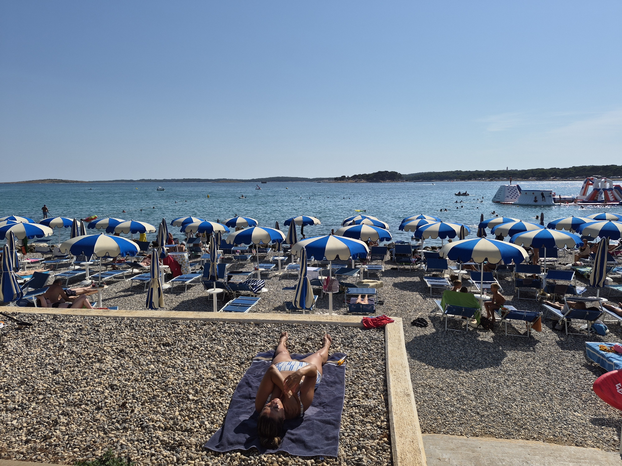 Sunny afternoon at a busy Croatian pebble beach