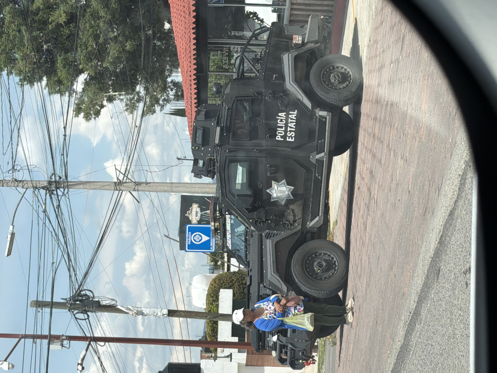 Armored state police vehicle on a brick sidewalk in Puebla