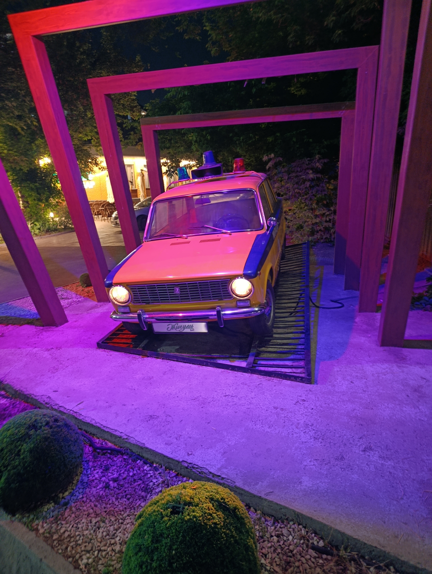 Vintage car displayed on metal ramp in Almaty art installation