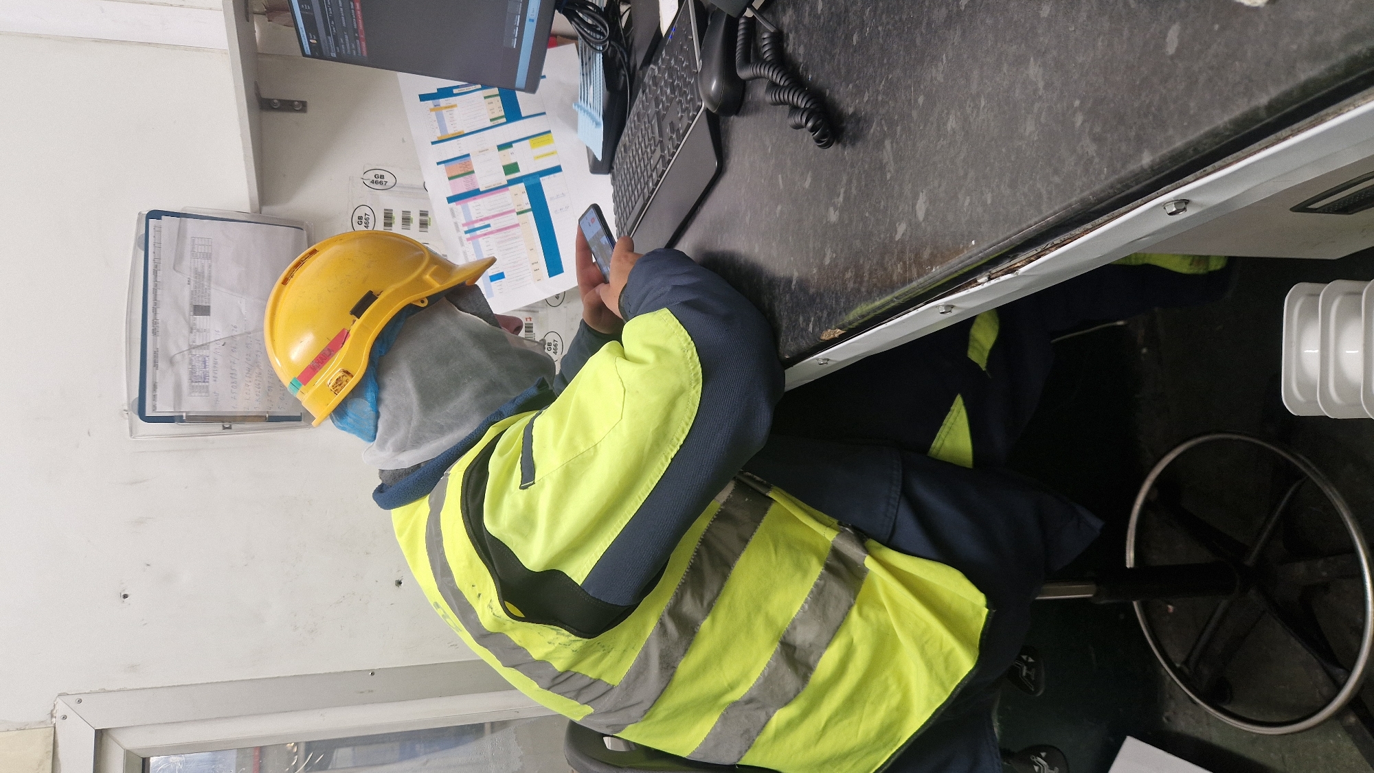 Safety worker uses phone at desk in Telford