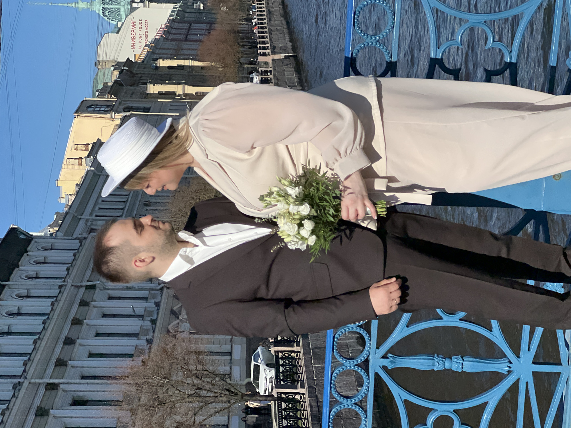 Newlyweds pose on Saint Petersburg bridge as boats pass below