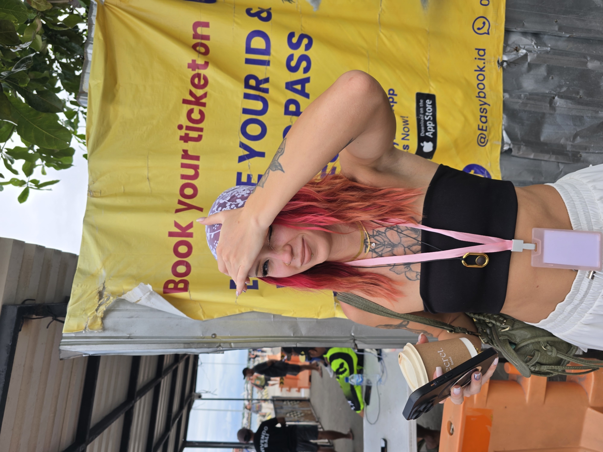 Pink-haired woman observed near transit booking signage