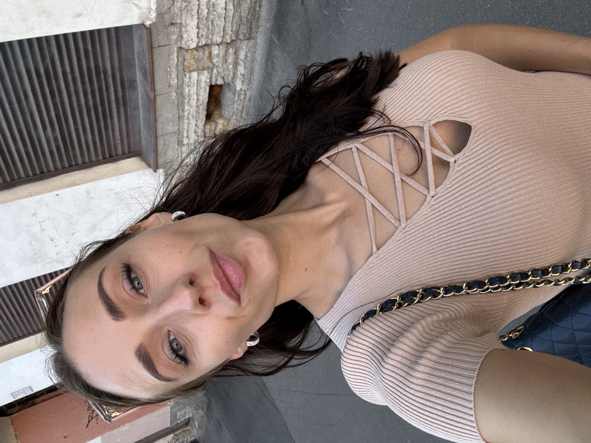 Close-up portrait in Saint Petersburg, neutral expression, pink knit top.
