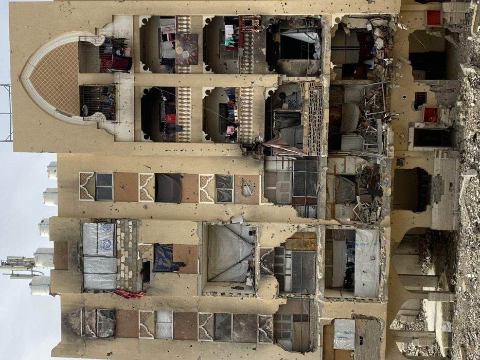 Khan Yunis residents grill food amid damaged buildings