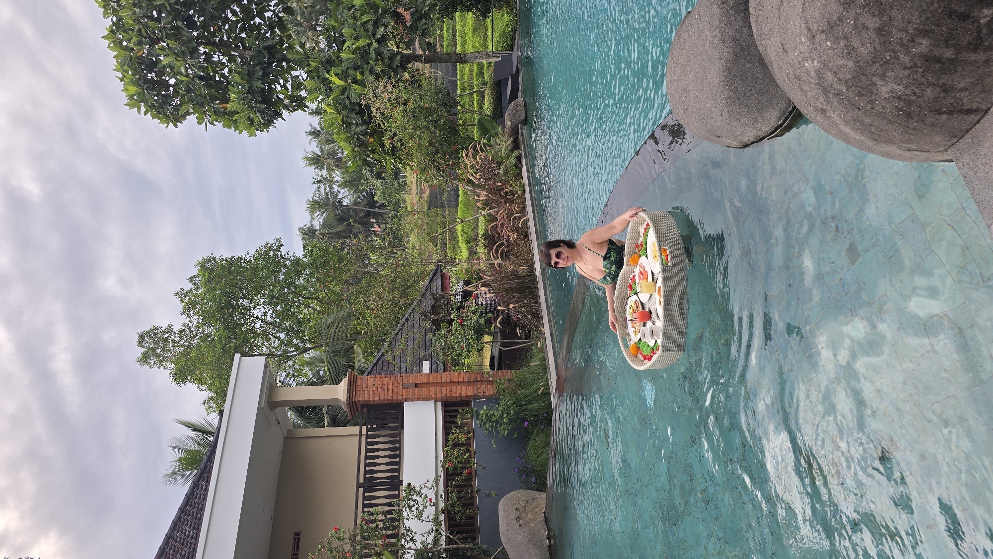 Woman enjoys floating pool service in tropical Ubud resort