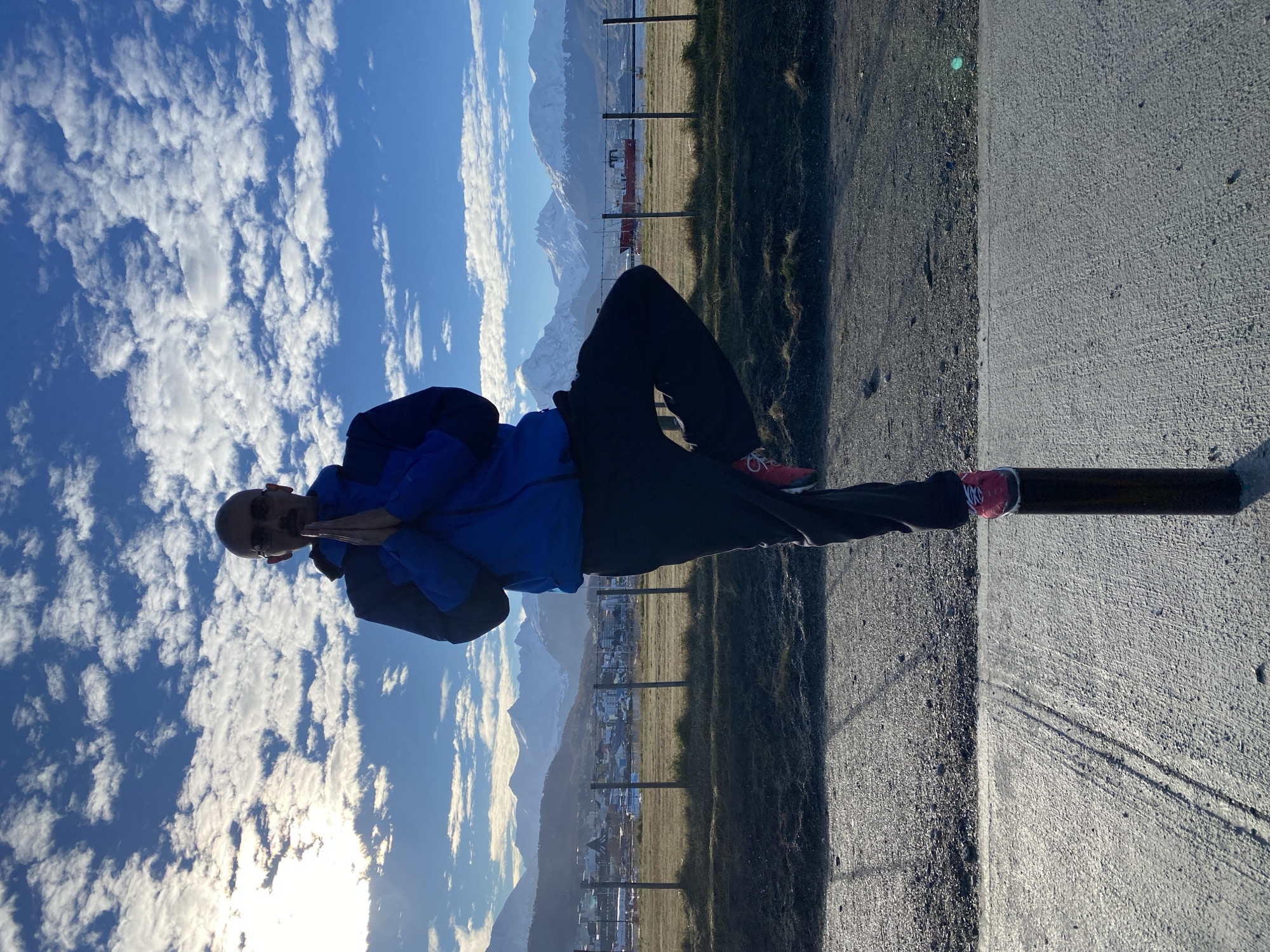 Man in blue jacket stands on path in Ushuaia