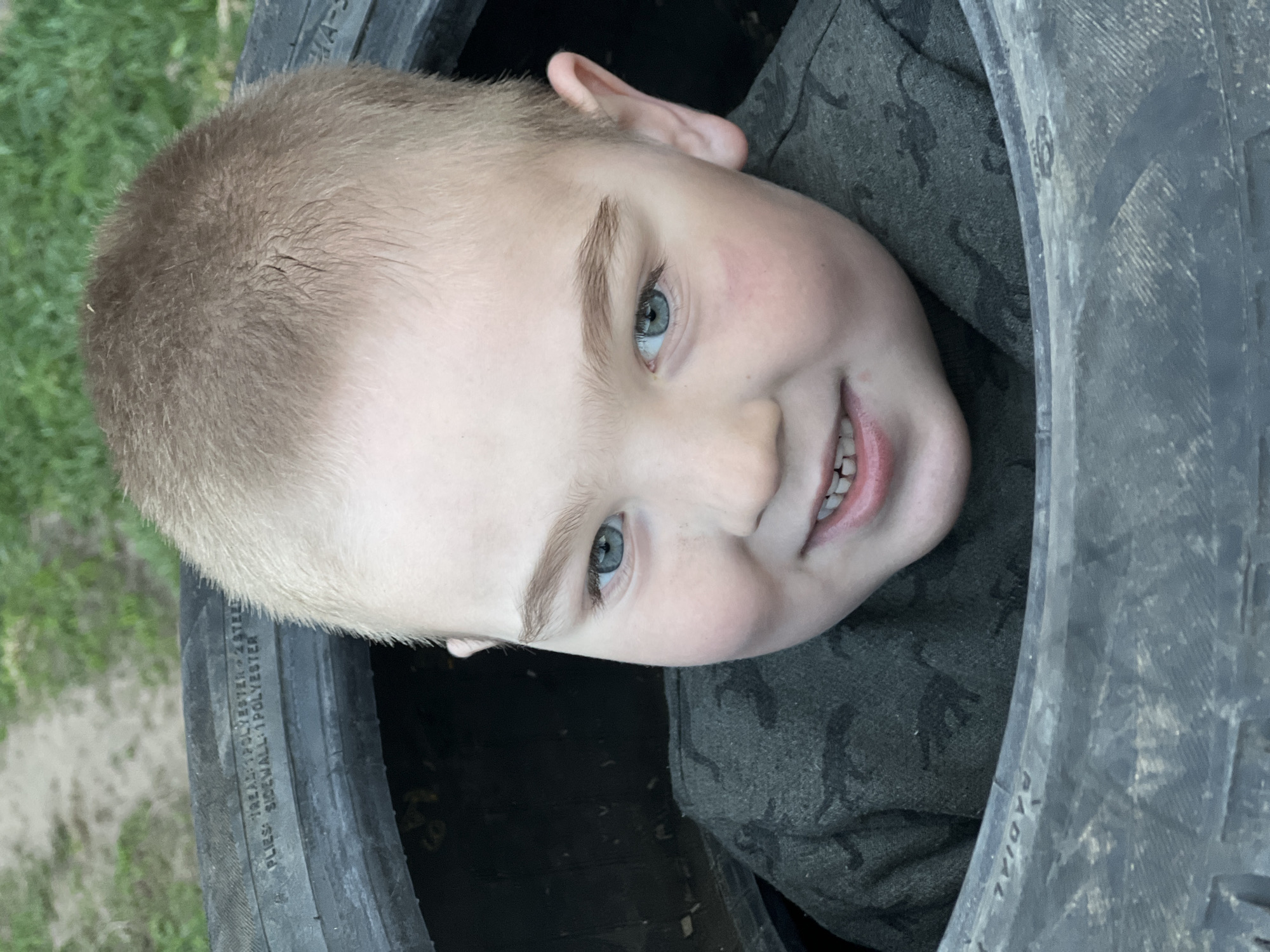 Boy plays in tire stack near Russian cabin