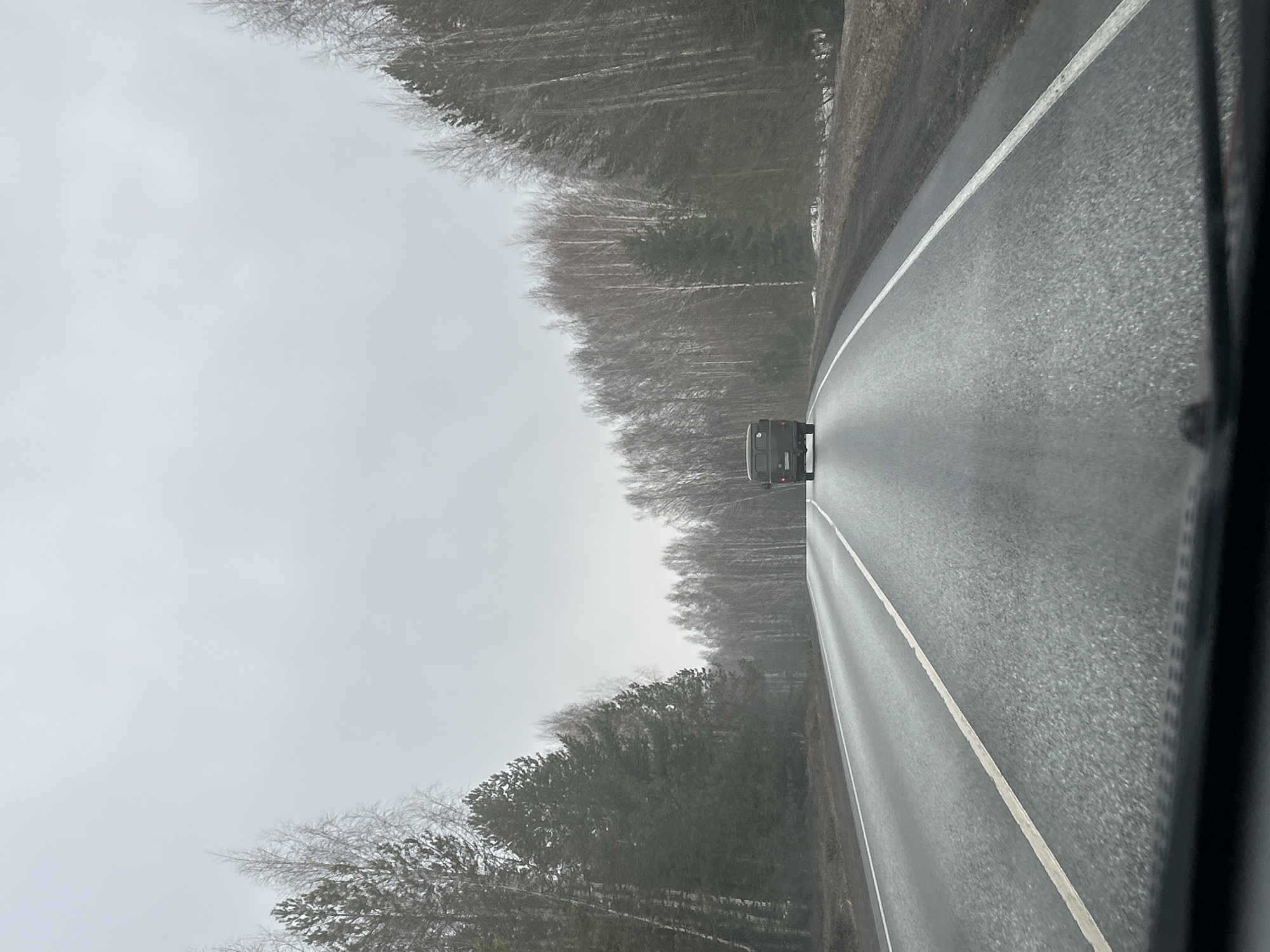 Vehicle travels wet road in Oralki, Russia