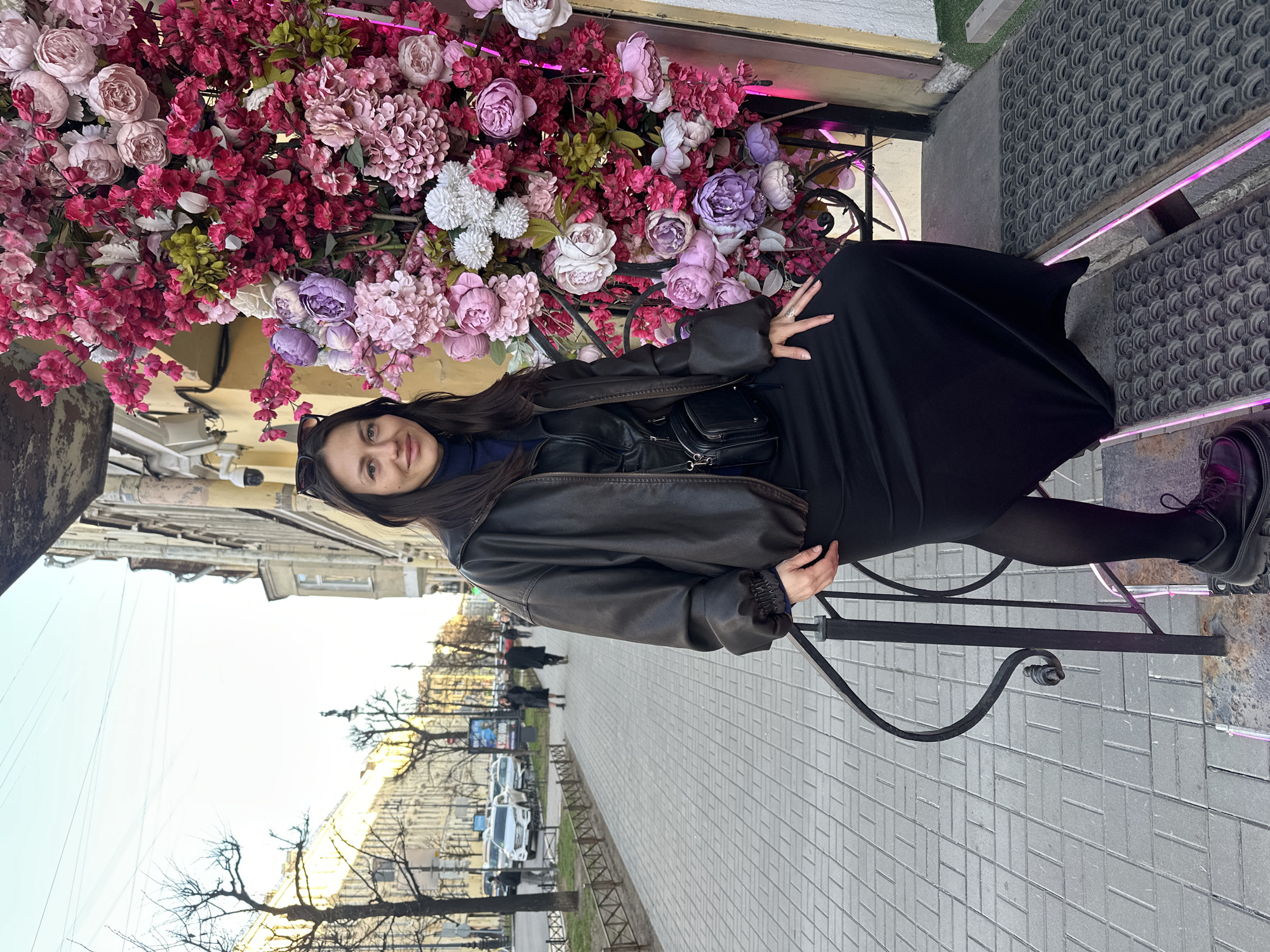 Woman sits by colorful flower display in Saint Petersburg
