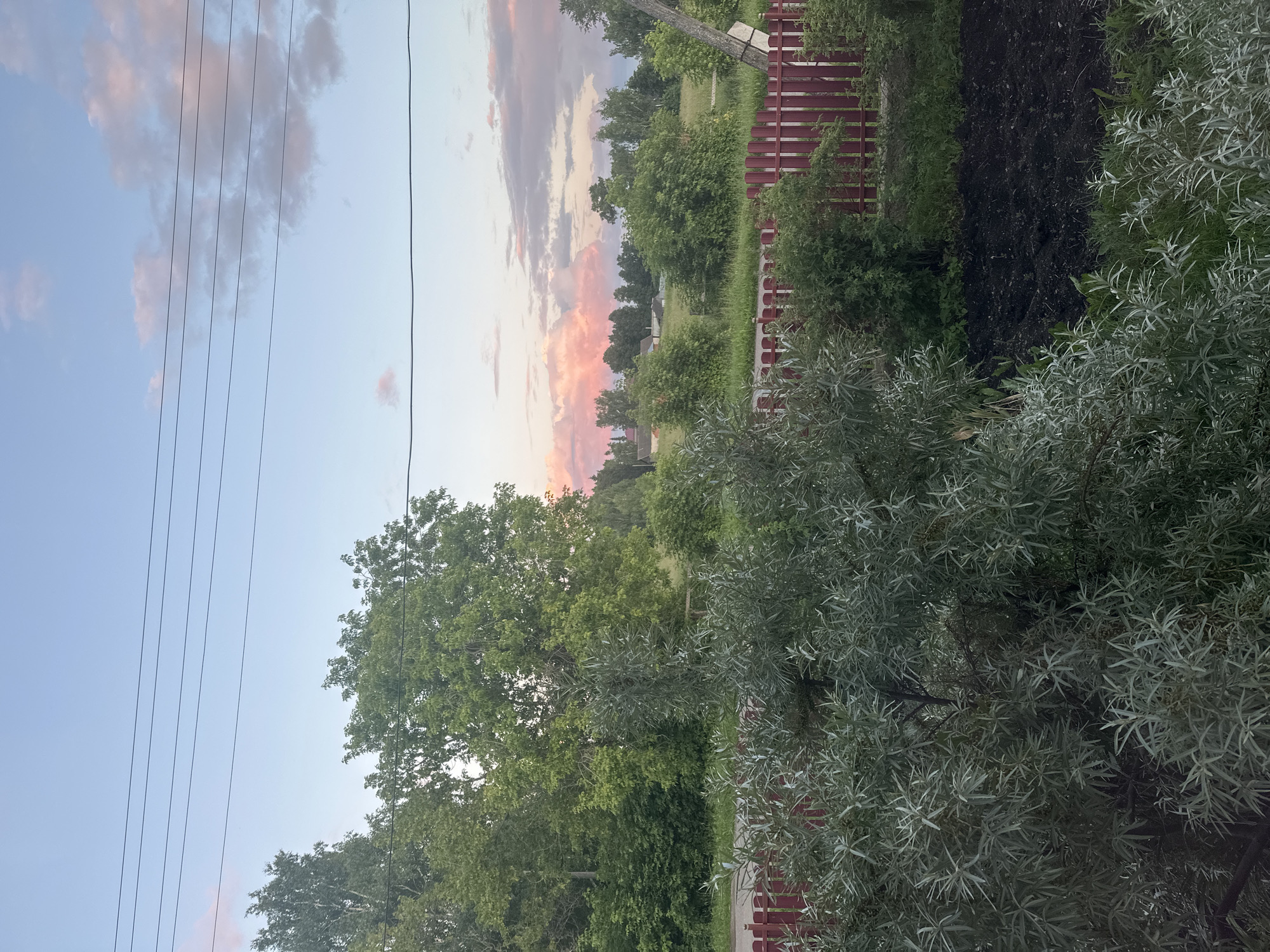 Rural Yaroslavka at sunset: power lines, gas pipes, and quiet backyards