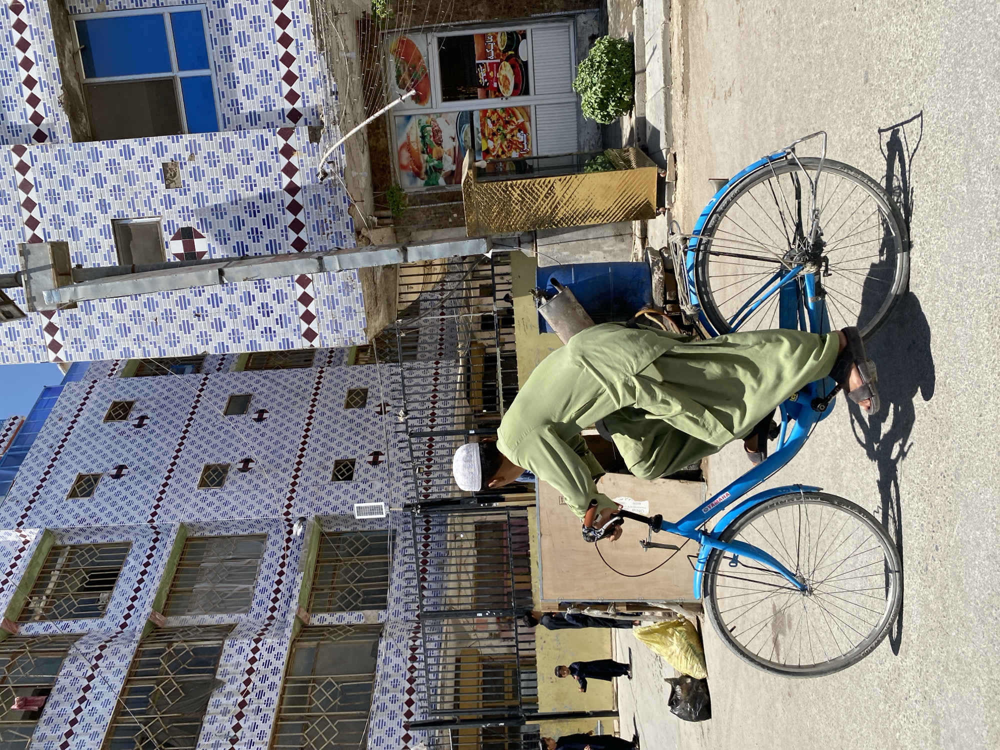 Street life in Kandahar: cycling and a roadside food stall