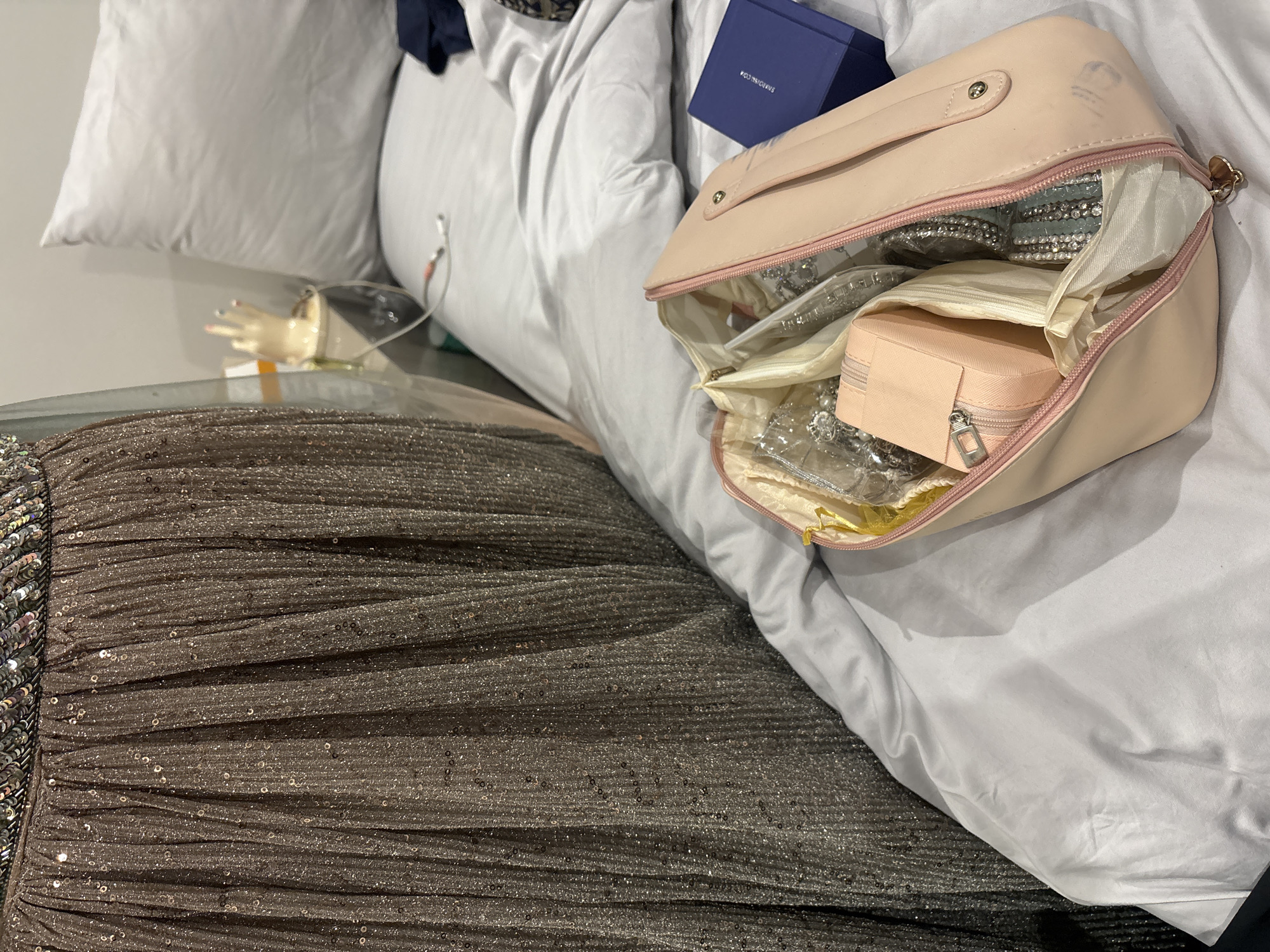 Personal items and jewelry organized on bedroom bedding in Durban
