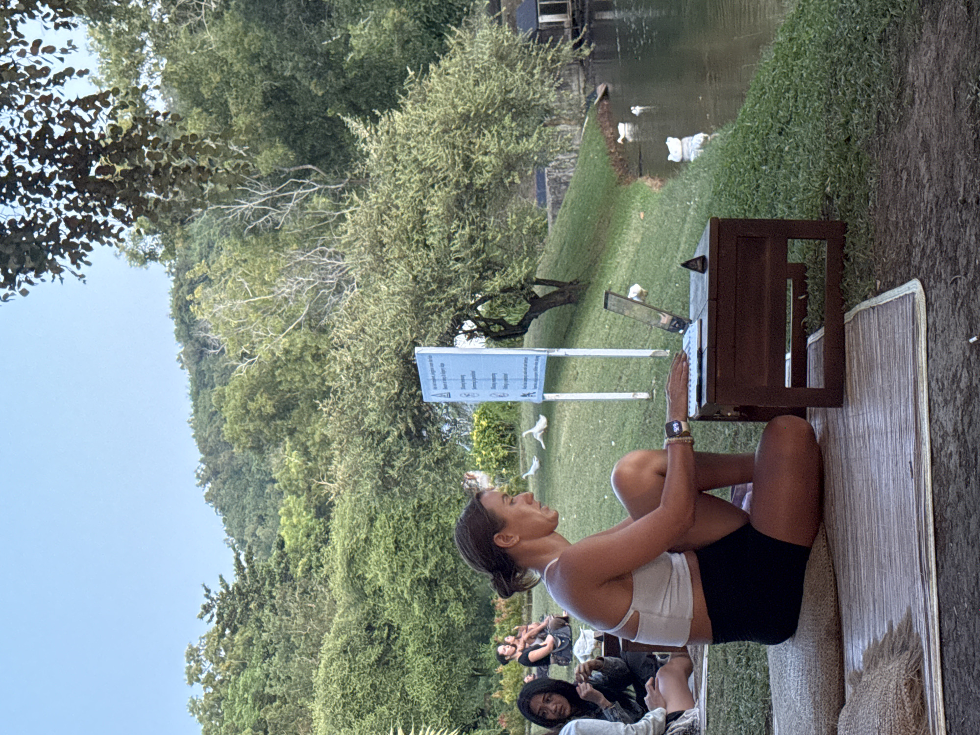 Young adults enjoy lakeside picnic with ducks in Pecatu