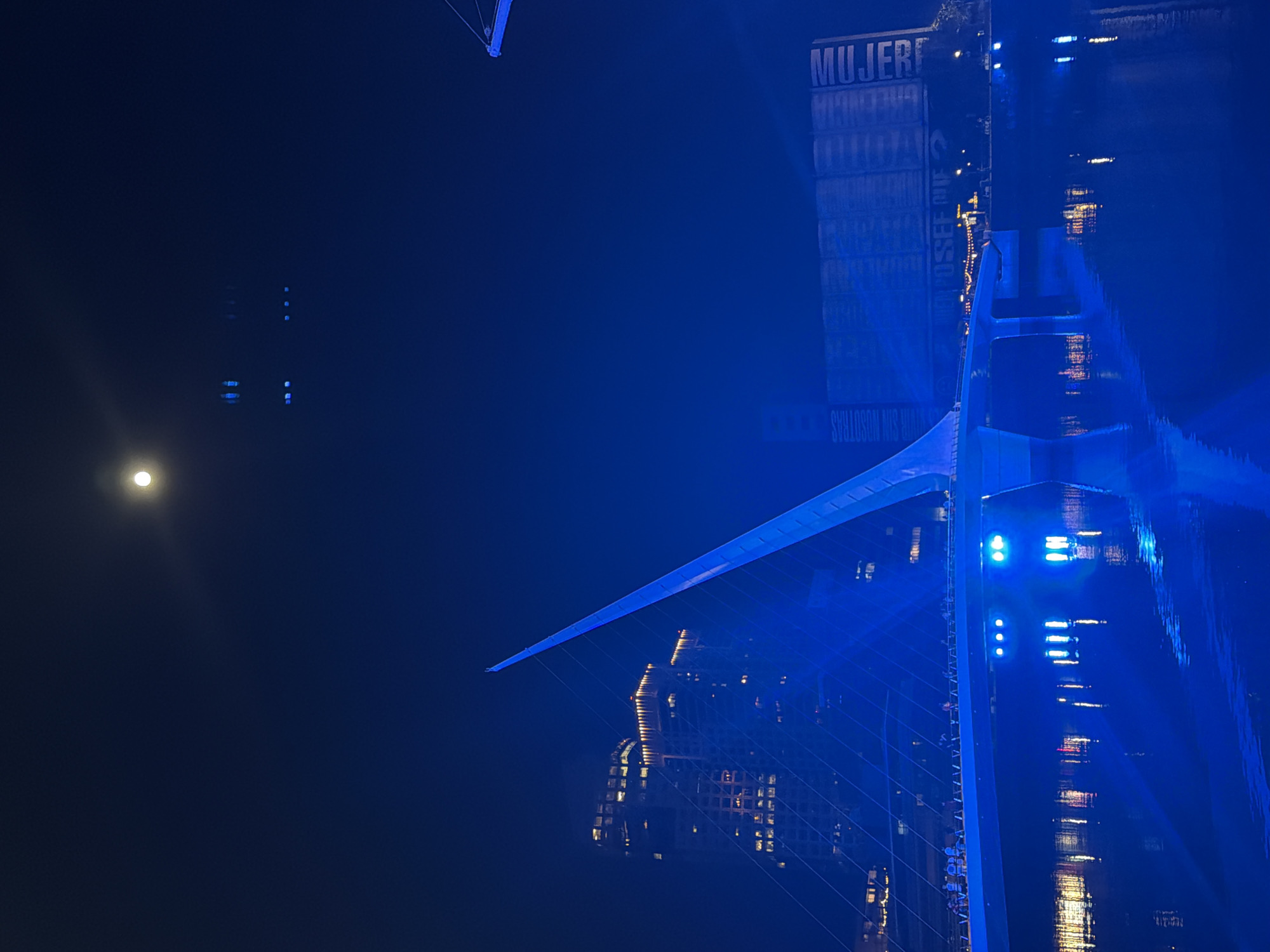 Buenos Aires Woman's Bridge glows blue in moonlit night
