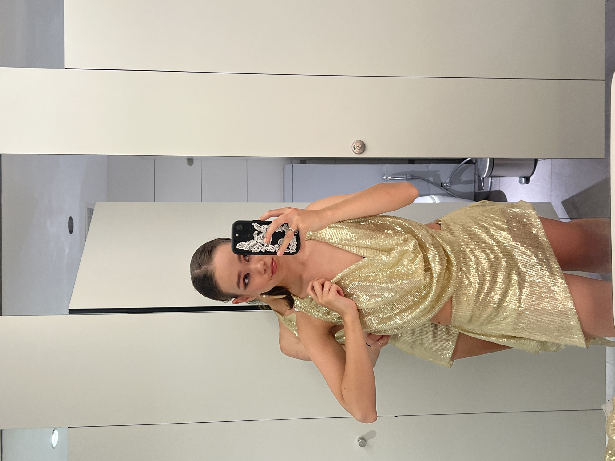 Woman takes bathroom selfie in gold dress in Vietnam
