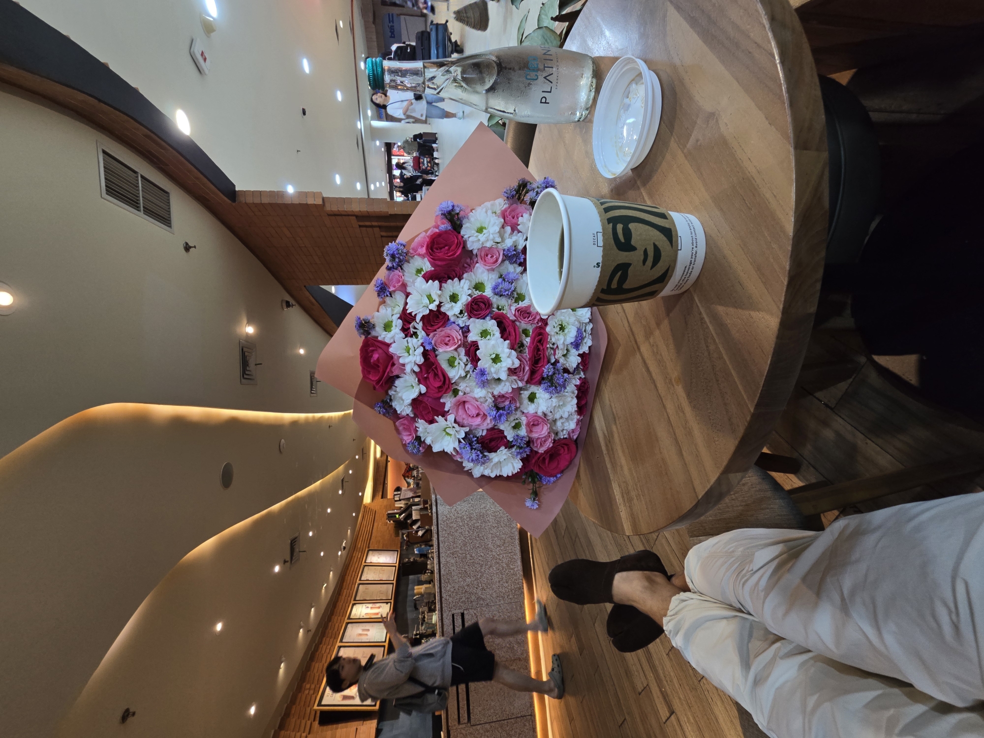 Person enjoys cafe time with flowers in Kuta
