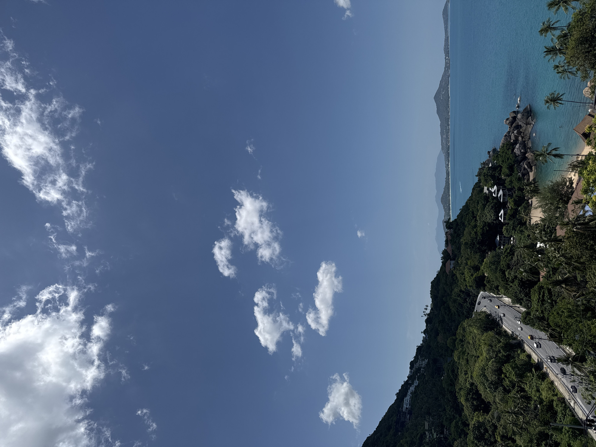 Winding coastal road cuts through Ko Samui on a clear day