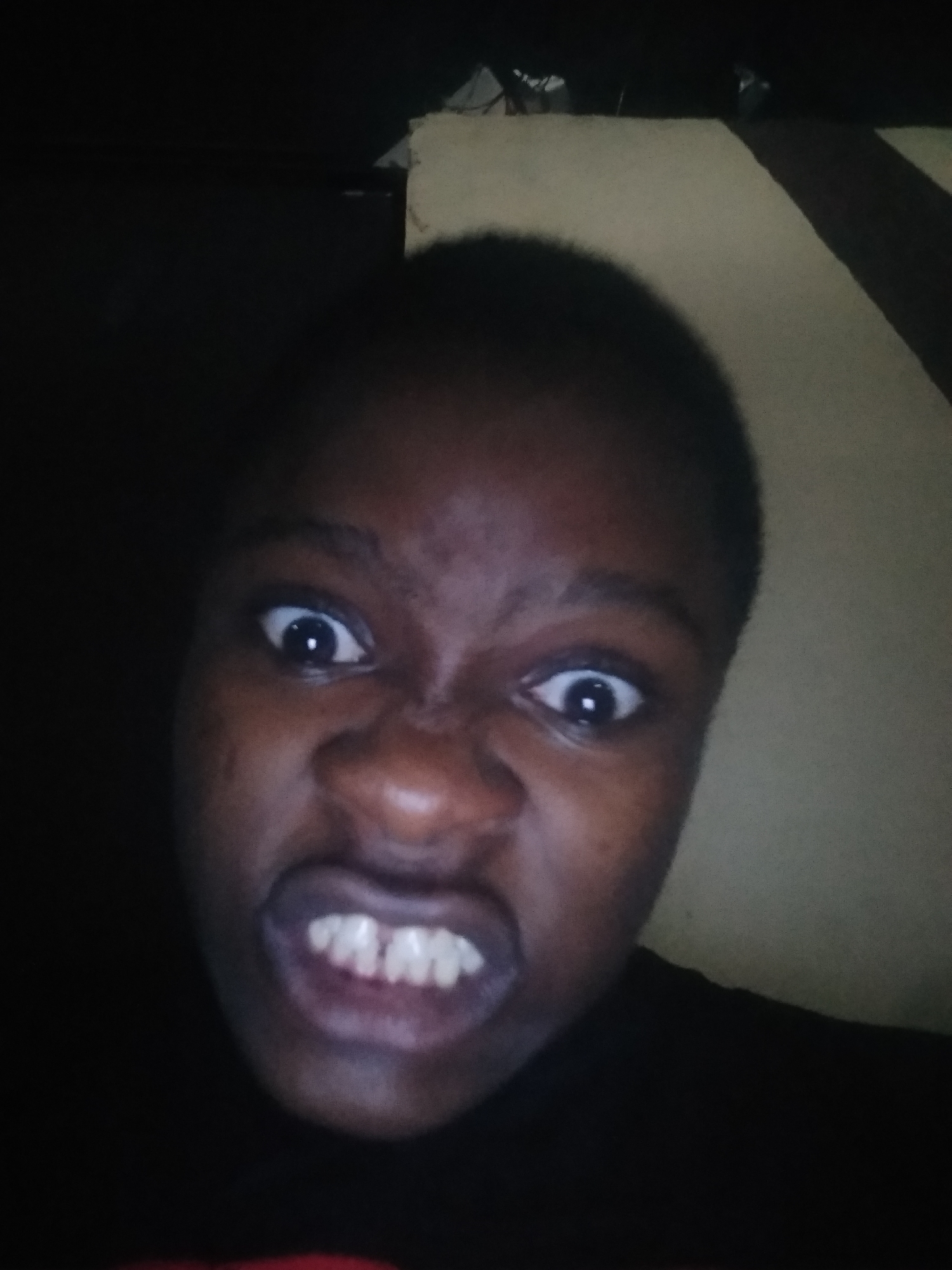 Person photographed making expressive faces indoors in Shangisha, Nigeria