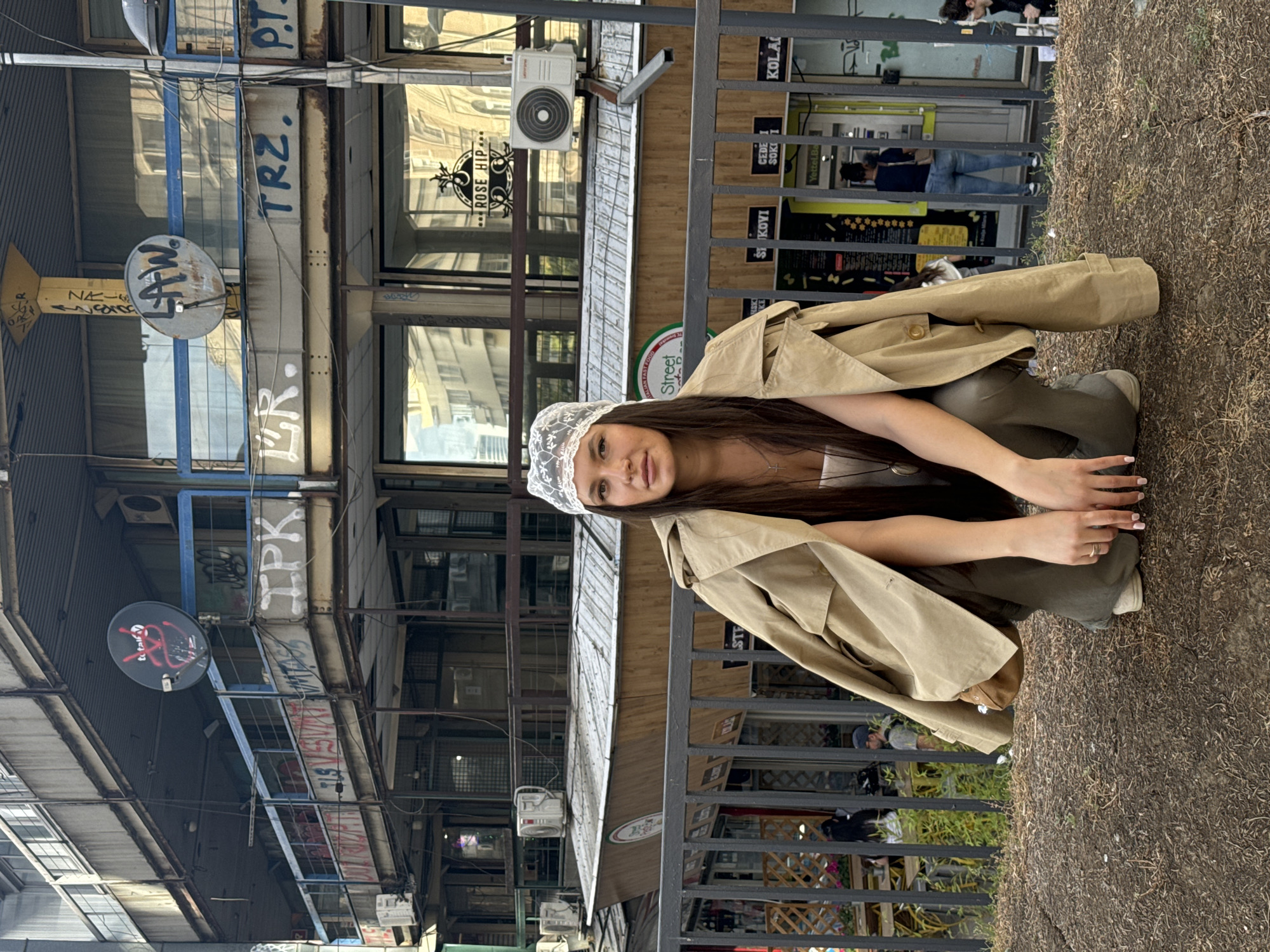 Woman poses for photos in lace headwear near Belgrade railing