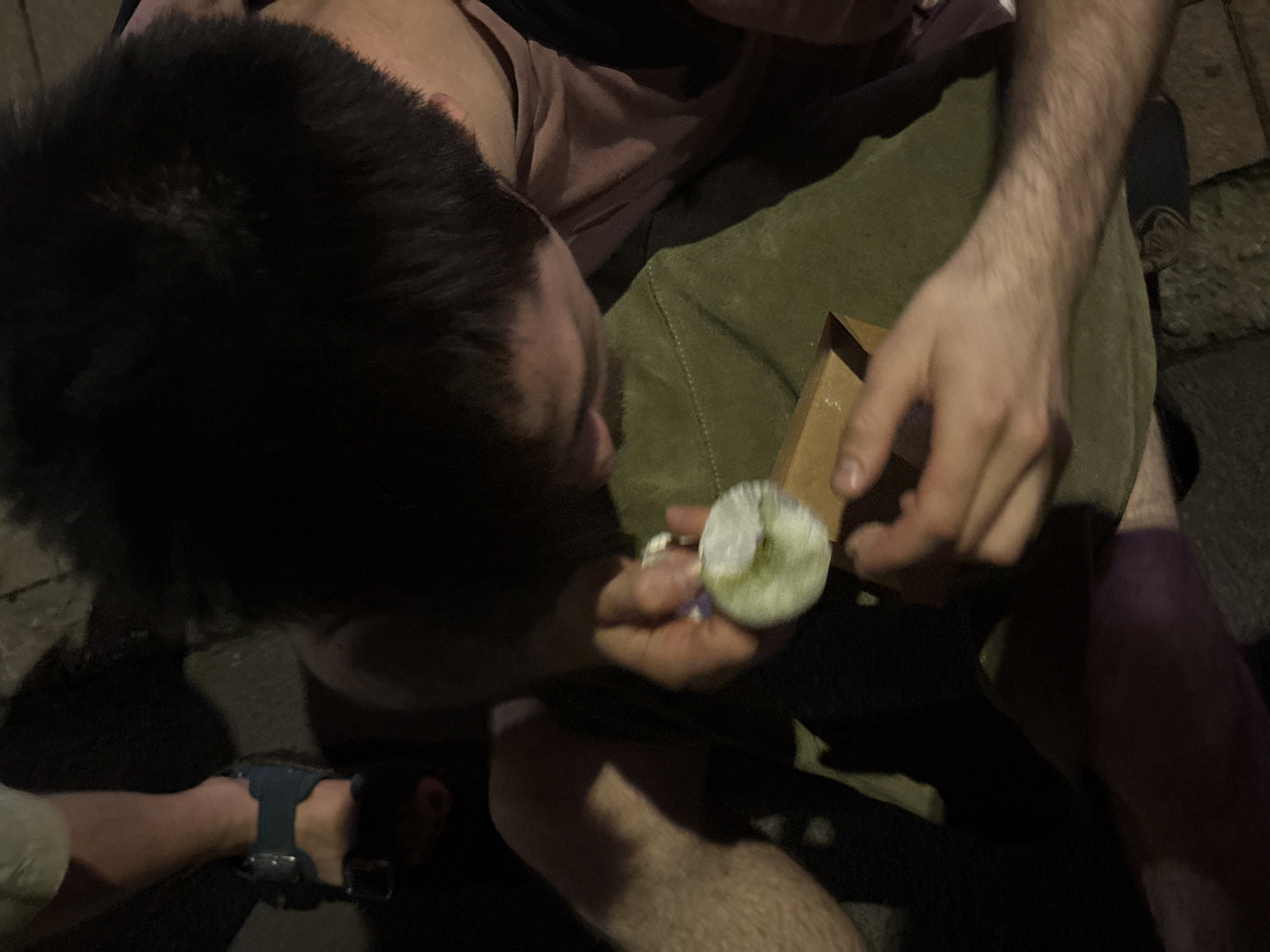 Young man eats outdoors on Milan street Saturday evening