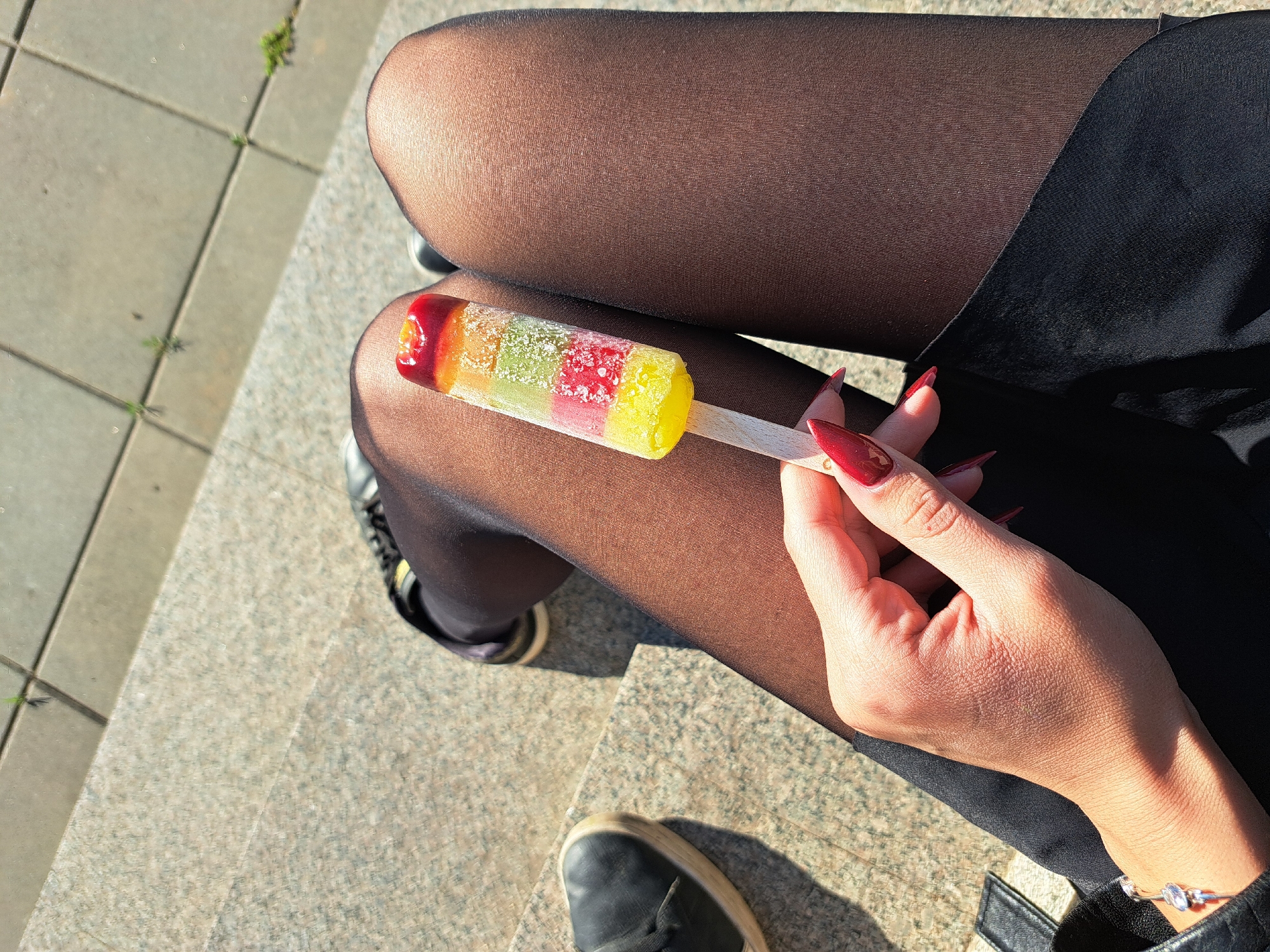 Casual popsicle moment captured on steps in Negovan, Bulgaria