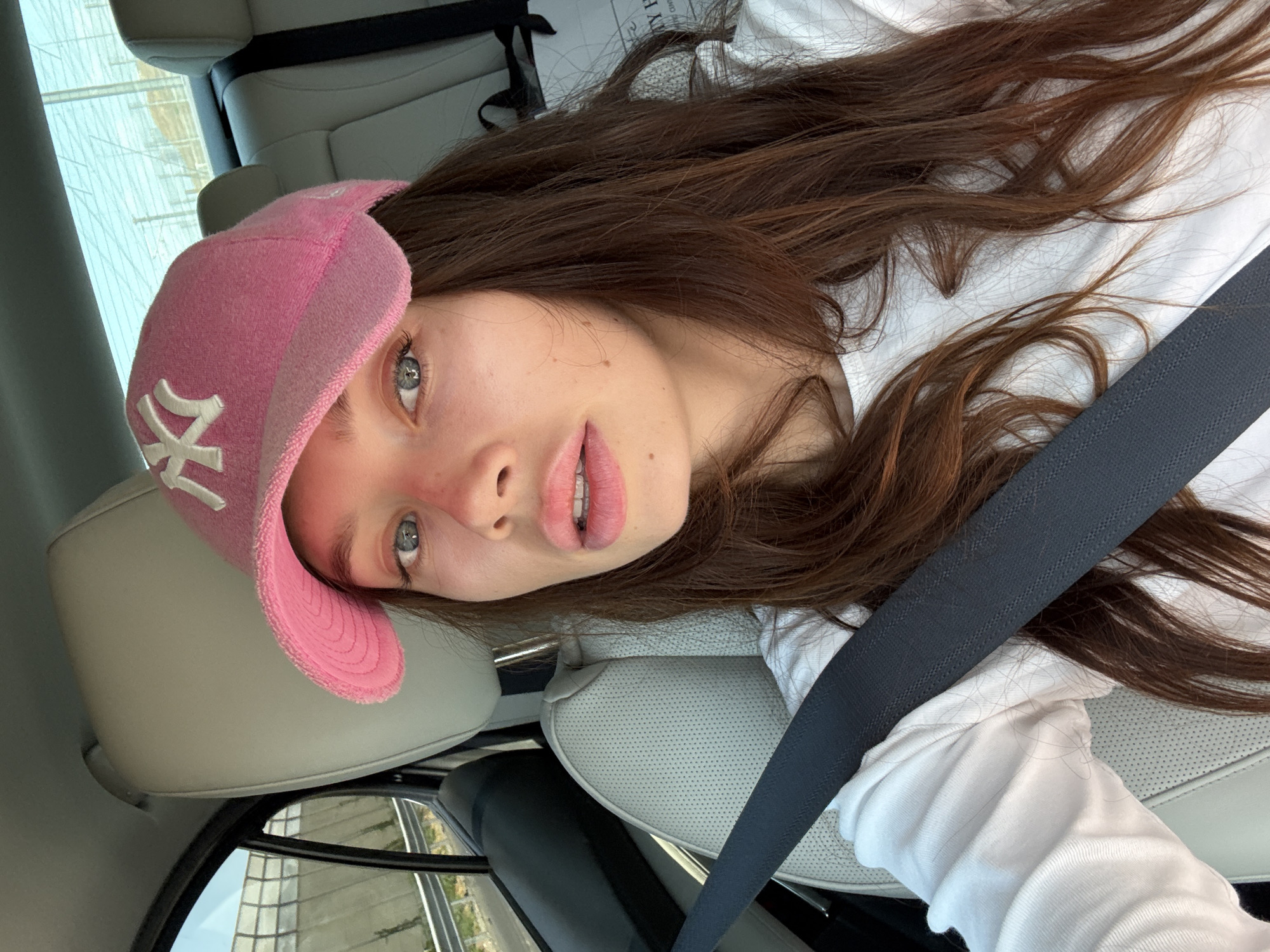 Passenger seat moment in Azor, pink NY cap in frame
