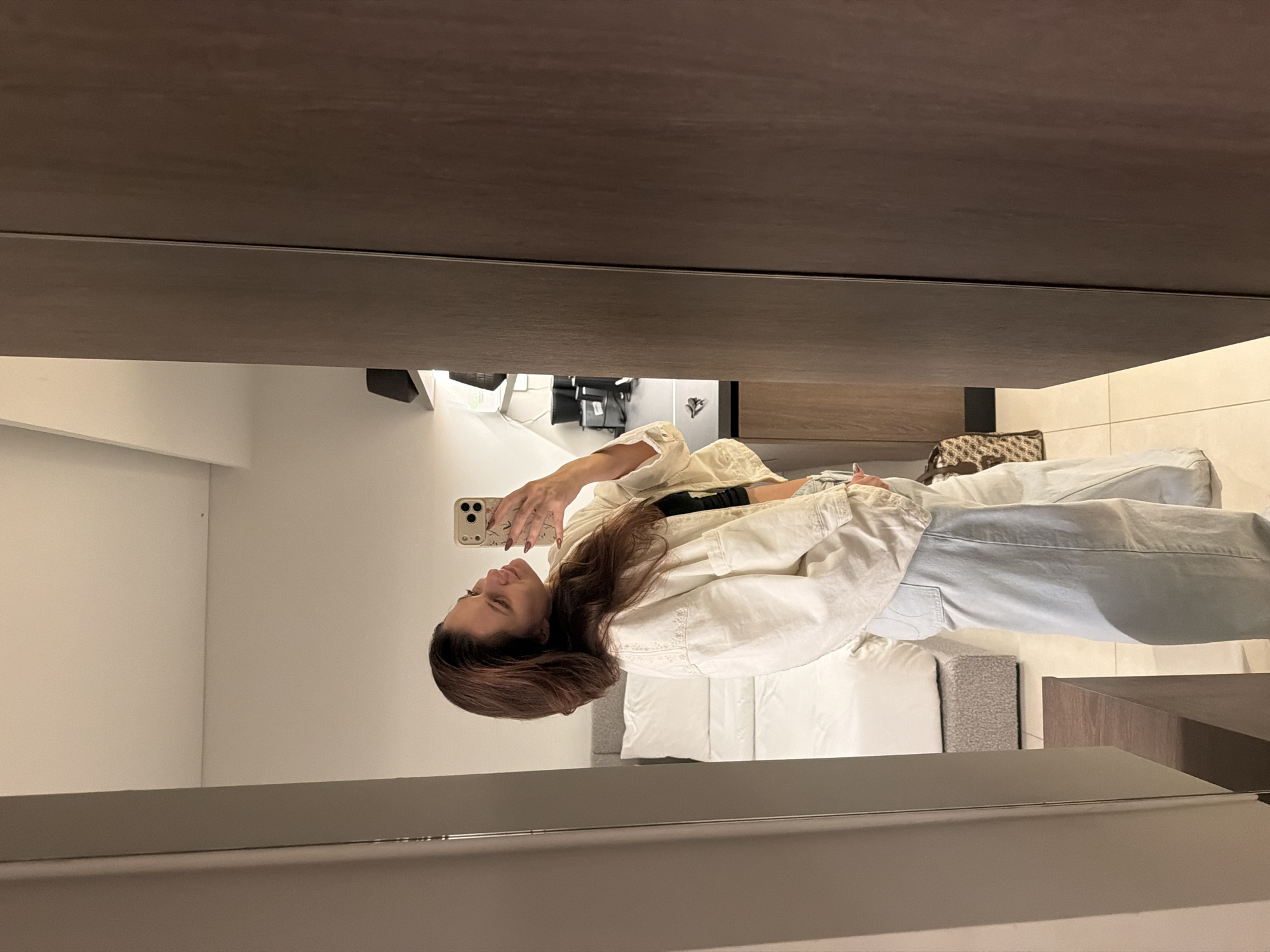 Person takes mirror selfie in modern Athens interior
