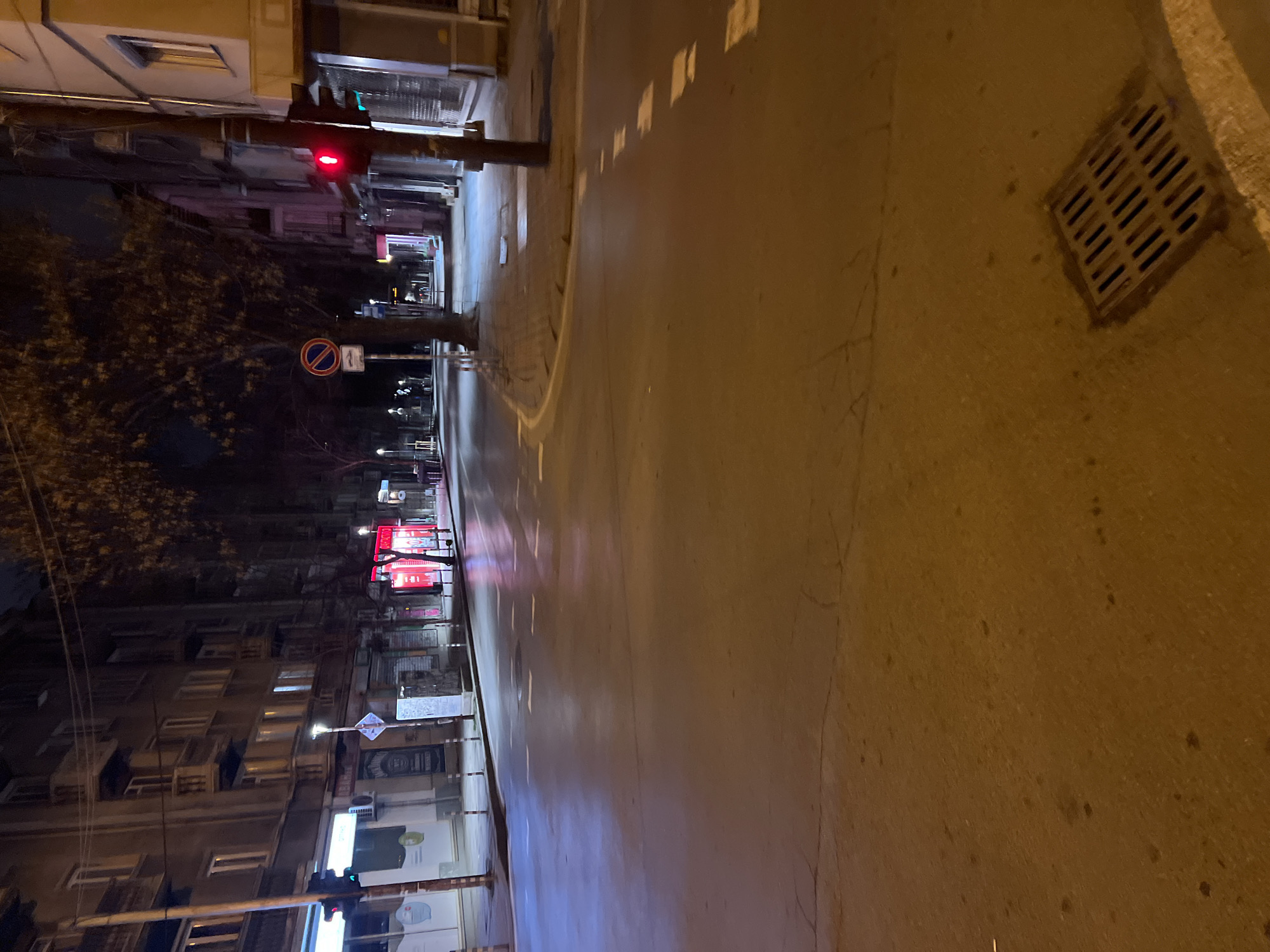 Wet street reflects city lights in nighttime Sofia