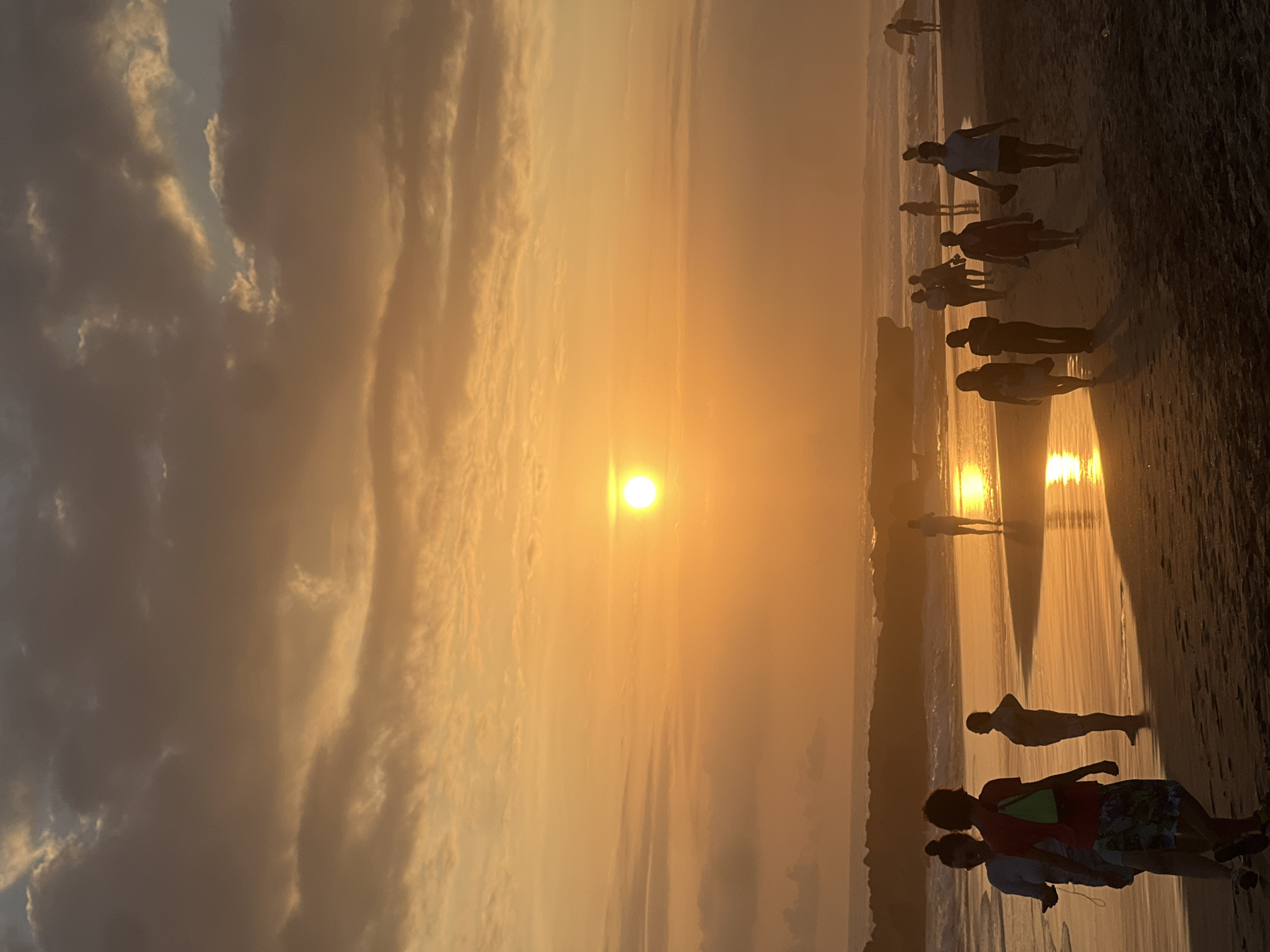 Sunset crowd on North Kuta beach with dogs and golden skies