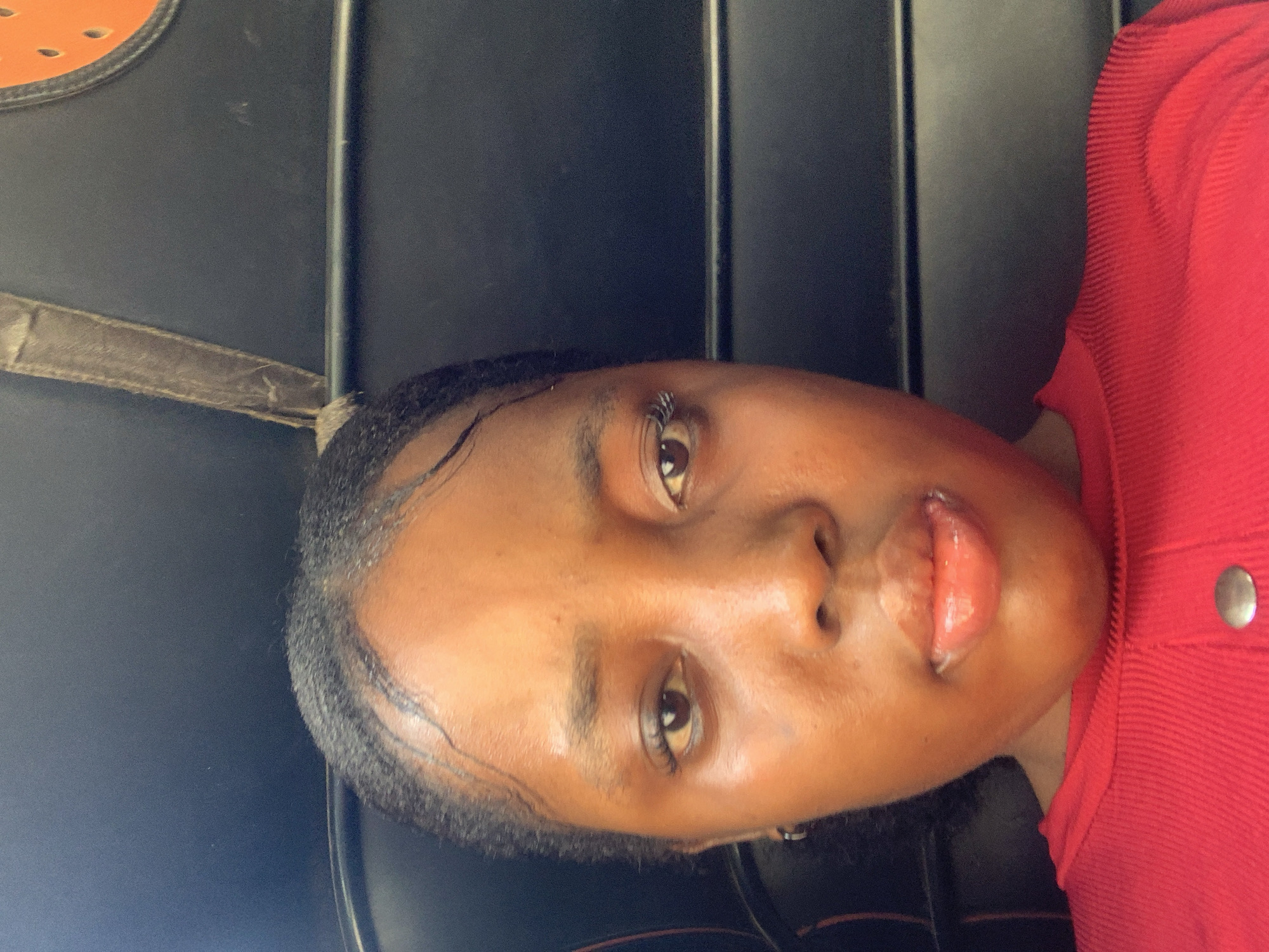 Woman takes selfie in red shirt in Aba, Nigeria