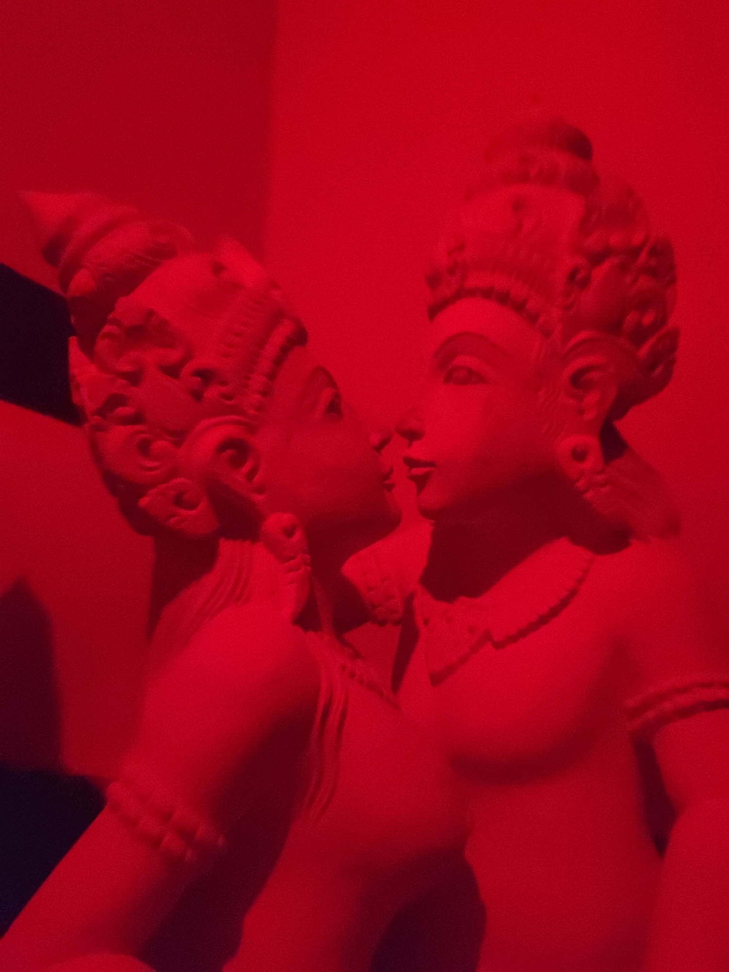 Stone statues photographed under red lighting in Ubud
