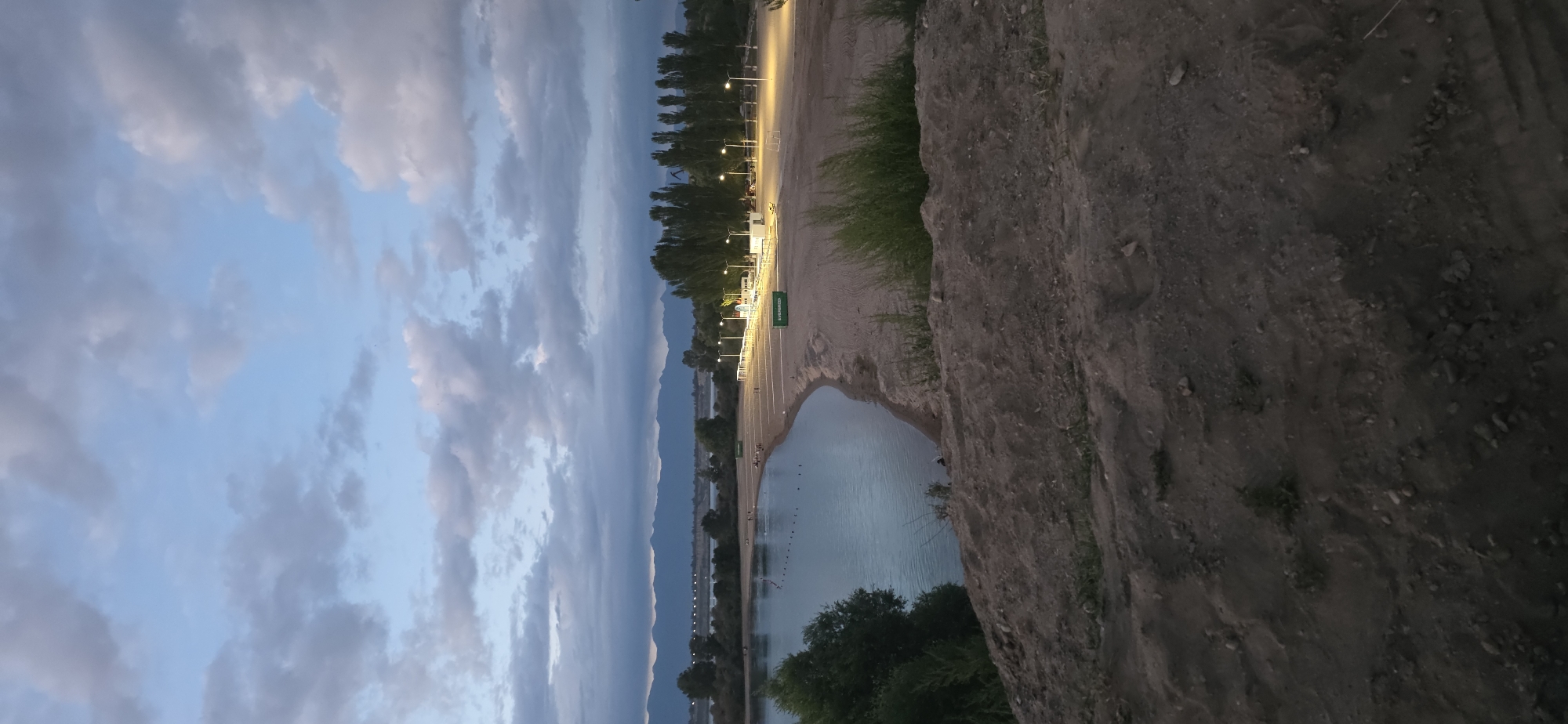 Dusk at a Kyrgyz lakeside beach, mountains on the horizon