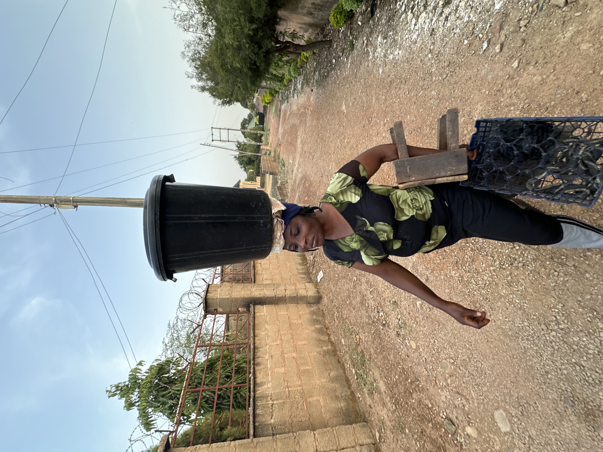 Woman carries container on head in Bukuru, Nigeria