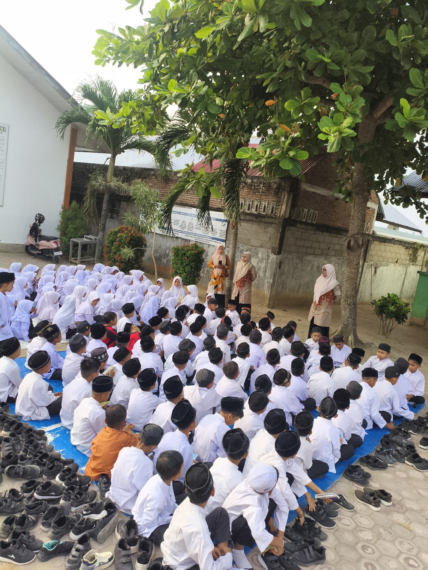 Children in Islamic dress gather for outdoor religious session in Indonesia